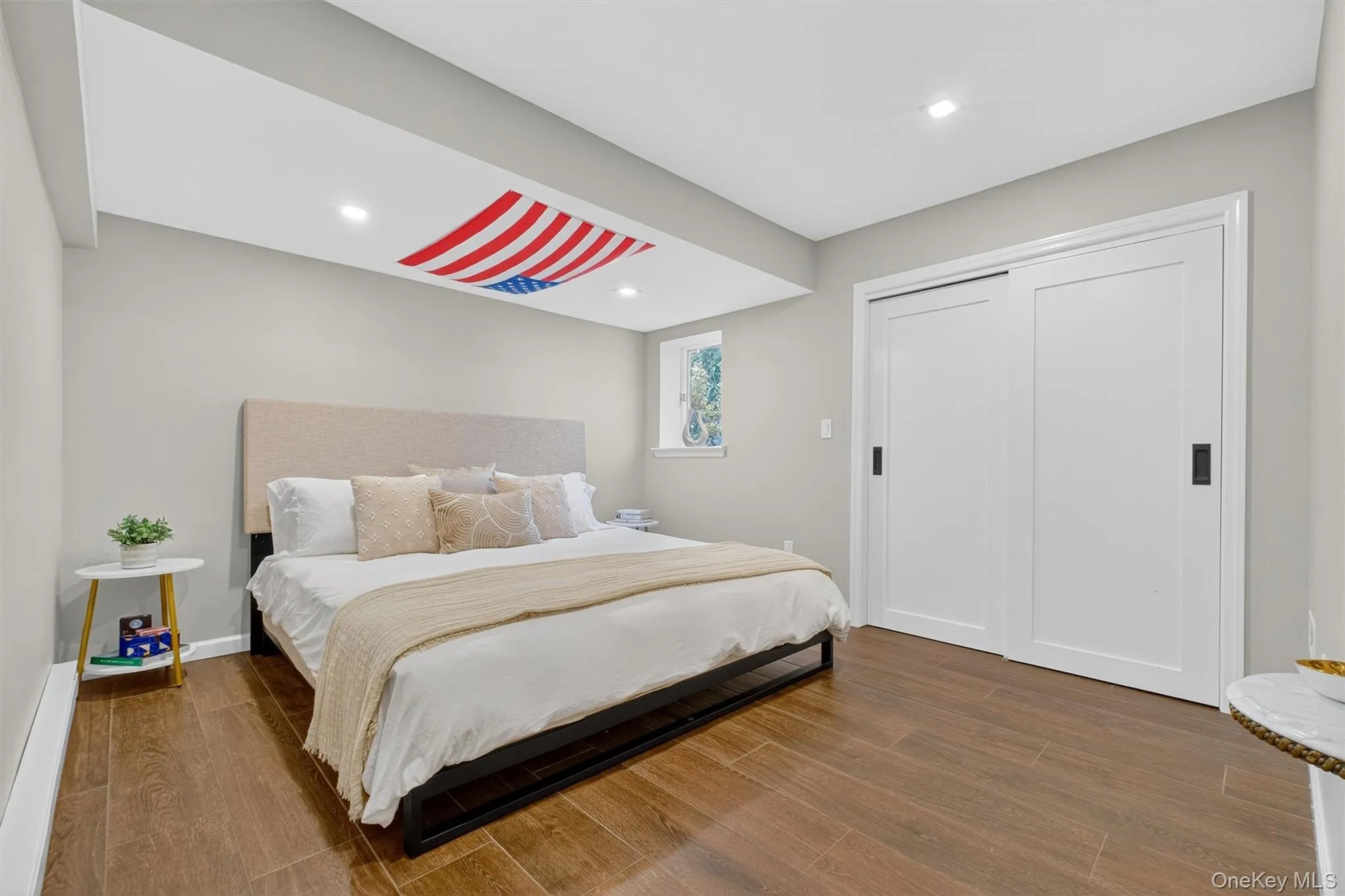 Downstairs bedroom with wood finished floors, recessed lighting, and a closet Downstairs bedroom with wood finished floors, recessed lighting, and a closet