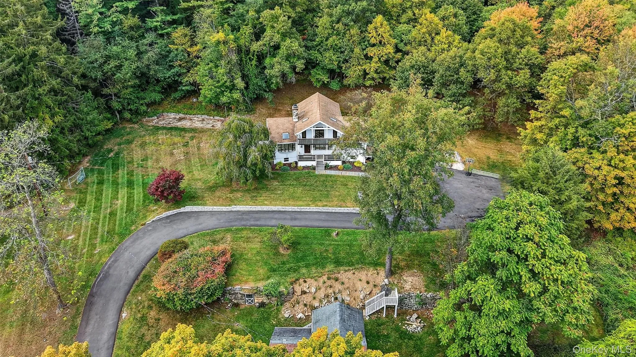 Aerial view of property and surrounding area featuring a heavily wooded area Aerial view of property and surrounding area featuring a heavily wooded area