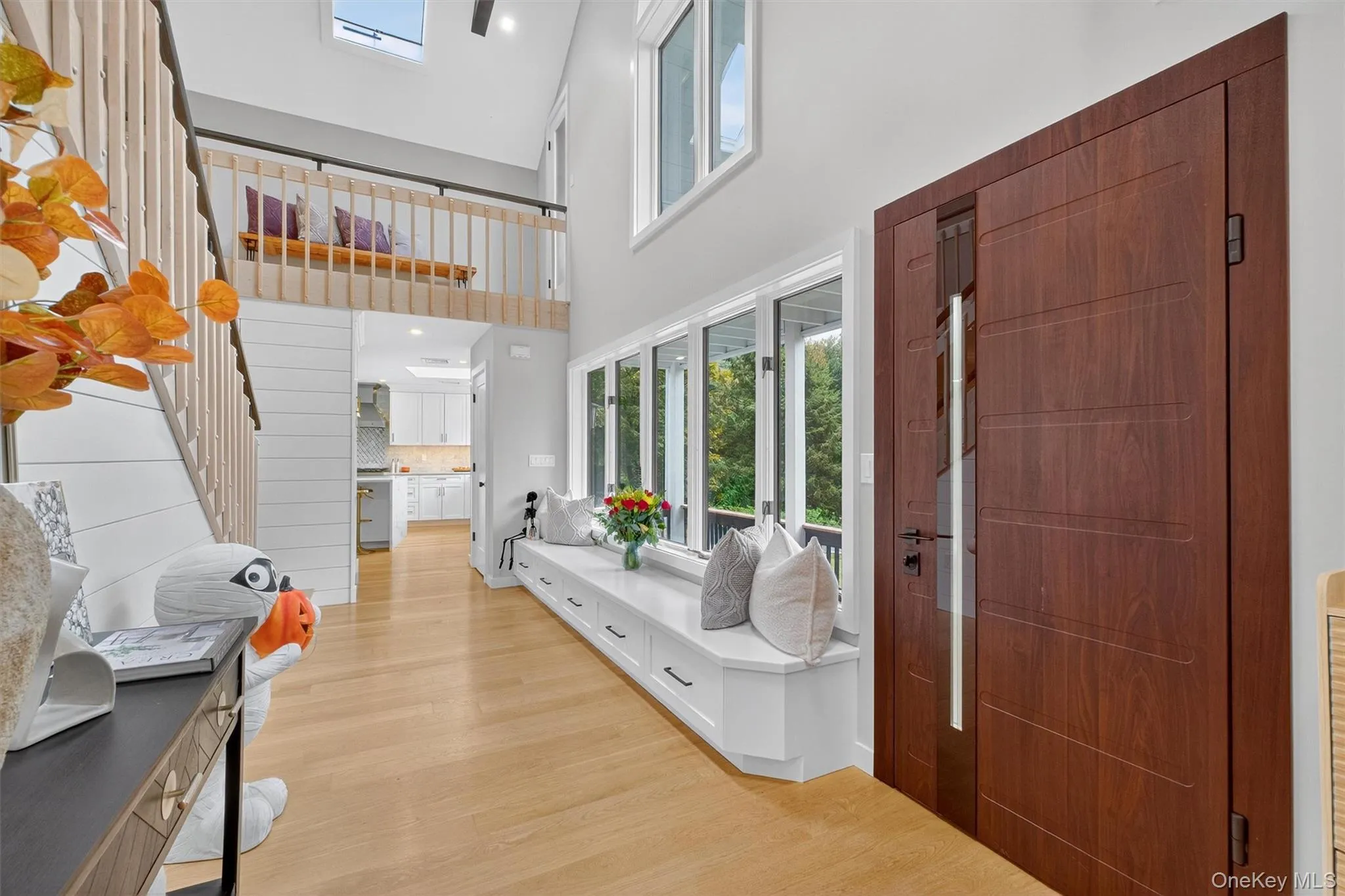 Foyer entrance featuring light wood flooring, plenty of natural light, a high ceiling, recessed lighting, and bench Foyer entrance featuring light wood flooring, plenty of natural light, a high ceiling, recessed lighting, and bench