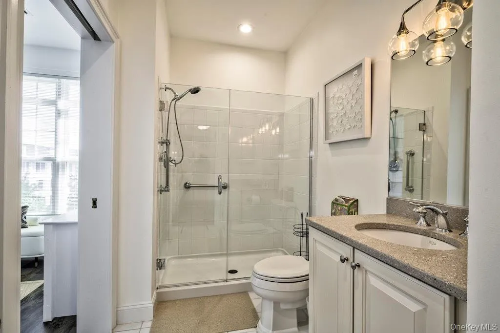 Bathroom with vanity, a shower stall, and light tile patterned floors Bathroom with vanity, a shower stall, and light tile patterned floors