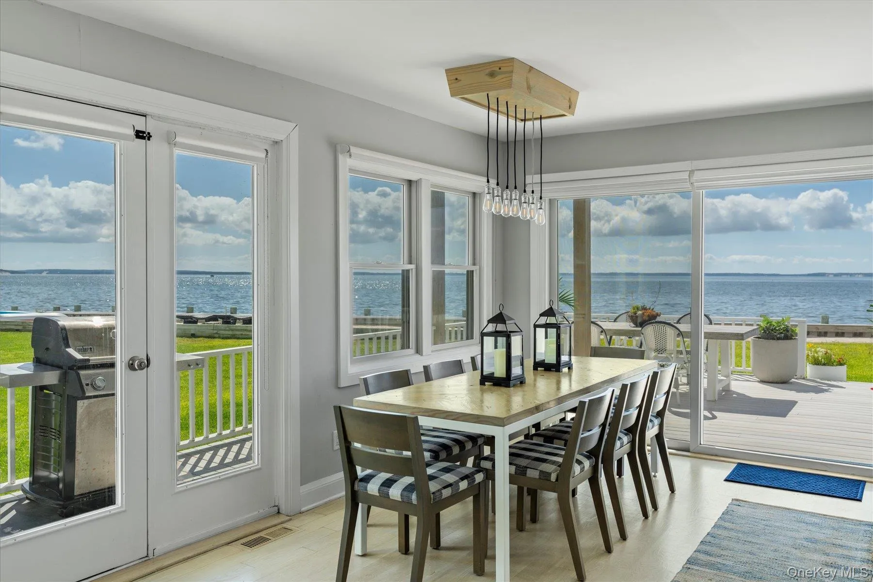 Dining space seamlessly connected to kitchen and living room with panoramic water views. Dining space seamlessly connected to kitchen and living room with panoramic water views.
