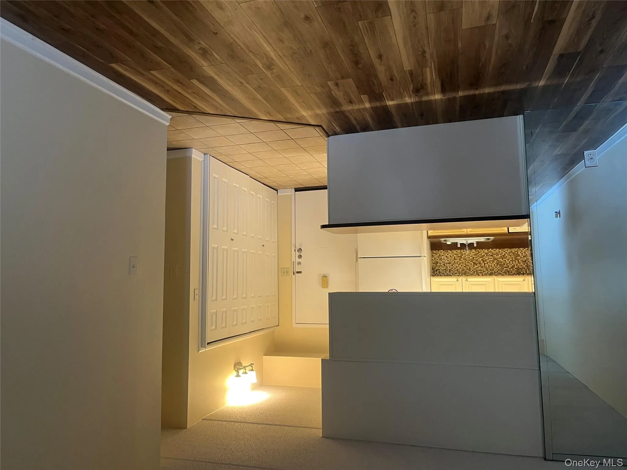 Kitchen featuring fridge, dark wood-type flooring, and dark countertops Kitchen featuring fridge, dark wood-type flooring, and dark countertops