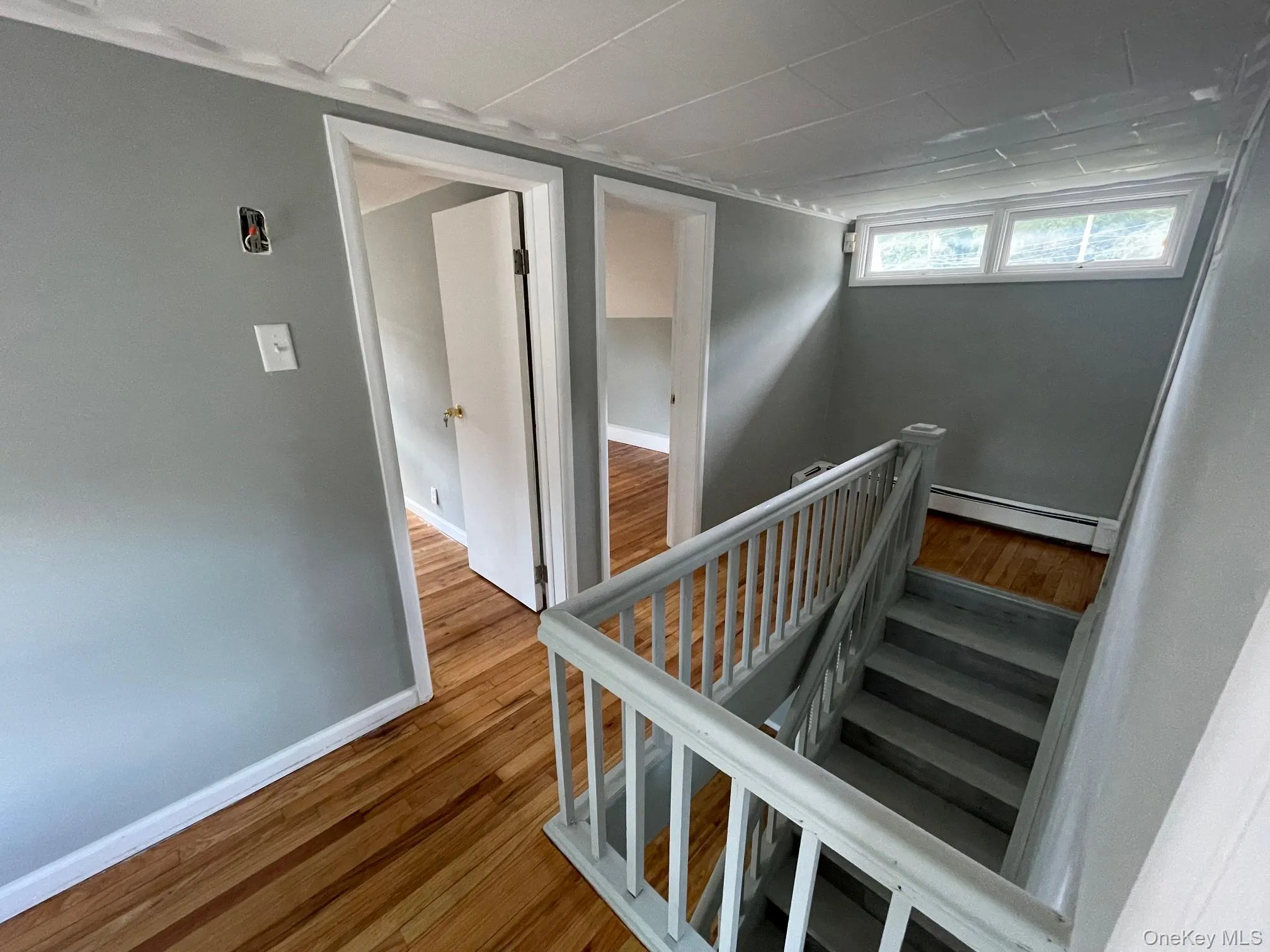 Stairway featuring wood finished floors and a baseboard radiator Stairway featuring wood finished floors and a baseboard radiator