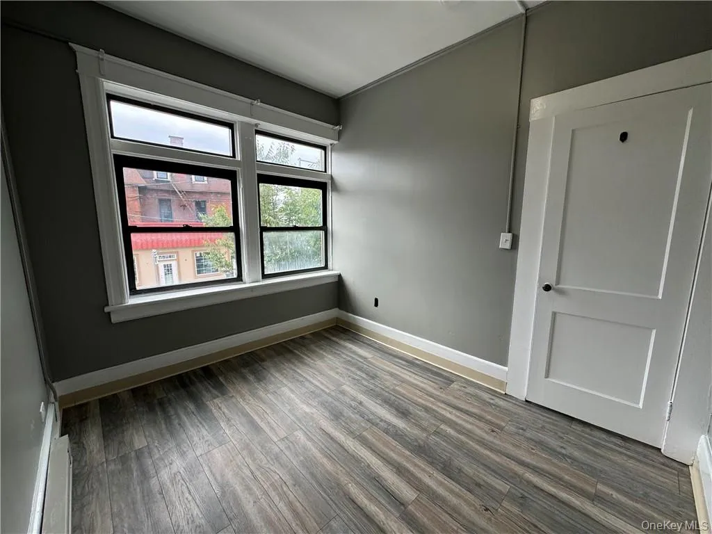 Spare room featuring wood-type flooring and baseboard heating Spare room featuring wood-type flooring and baseboard heating
