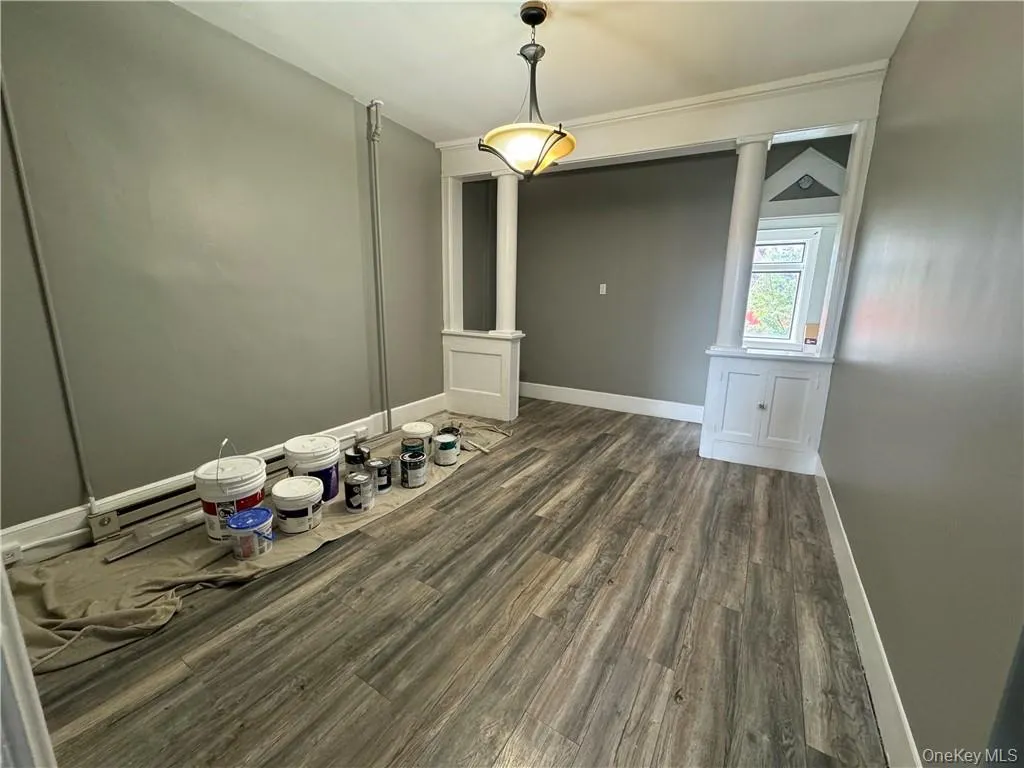 Unfurnished dining area with dark wood-type flooring and ornate columns Unfurnished dining area with dark wood-type flooring and ornate columns