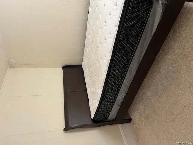 Bedroom with carpet flooring and wooden walls Bedroom with carpet flooring and wooden walls