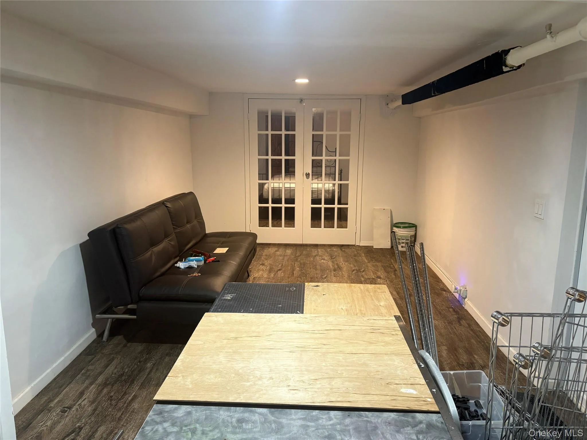 Living room featuring dark wood-style flooring and french doors Living room featuring dark wood-style flooring and french doors