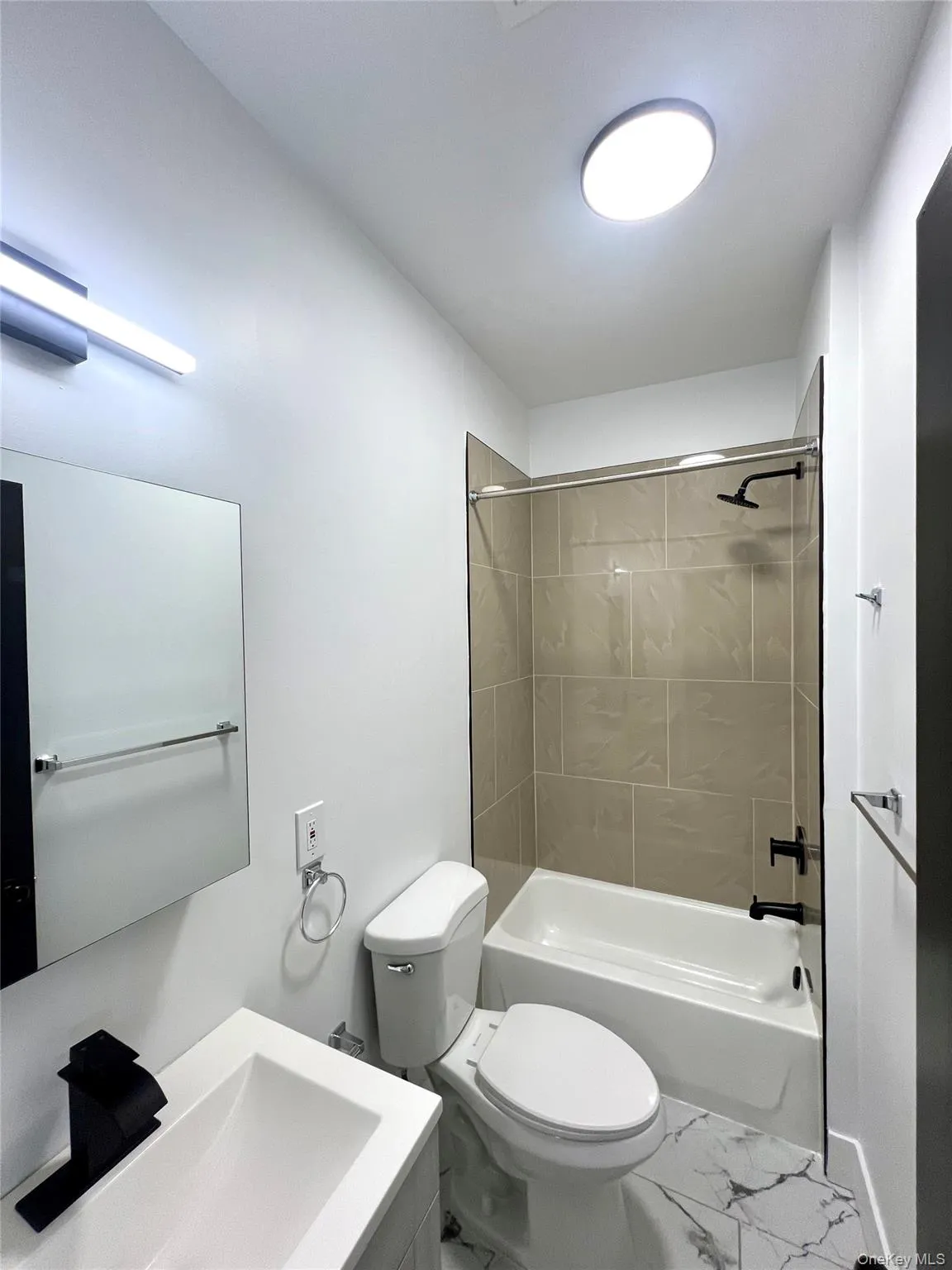 Bathroom featuring tub / shower combination, marble finish floors, and vanity Bathroom featuring tub / shower combination, marble finish floors, and vanity