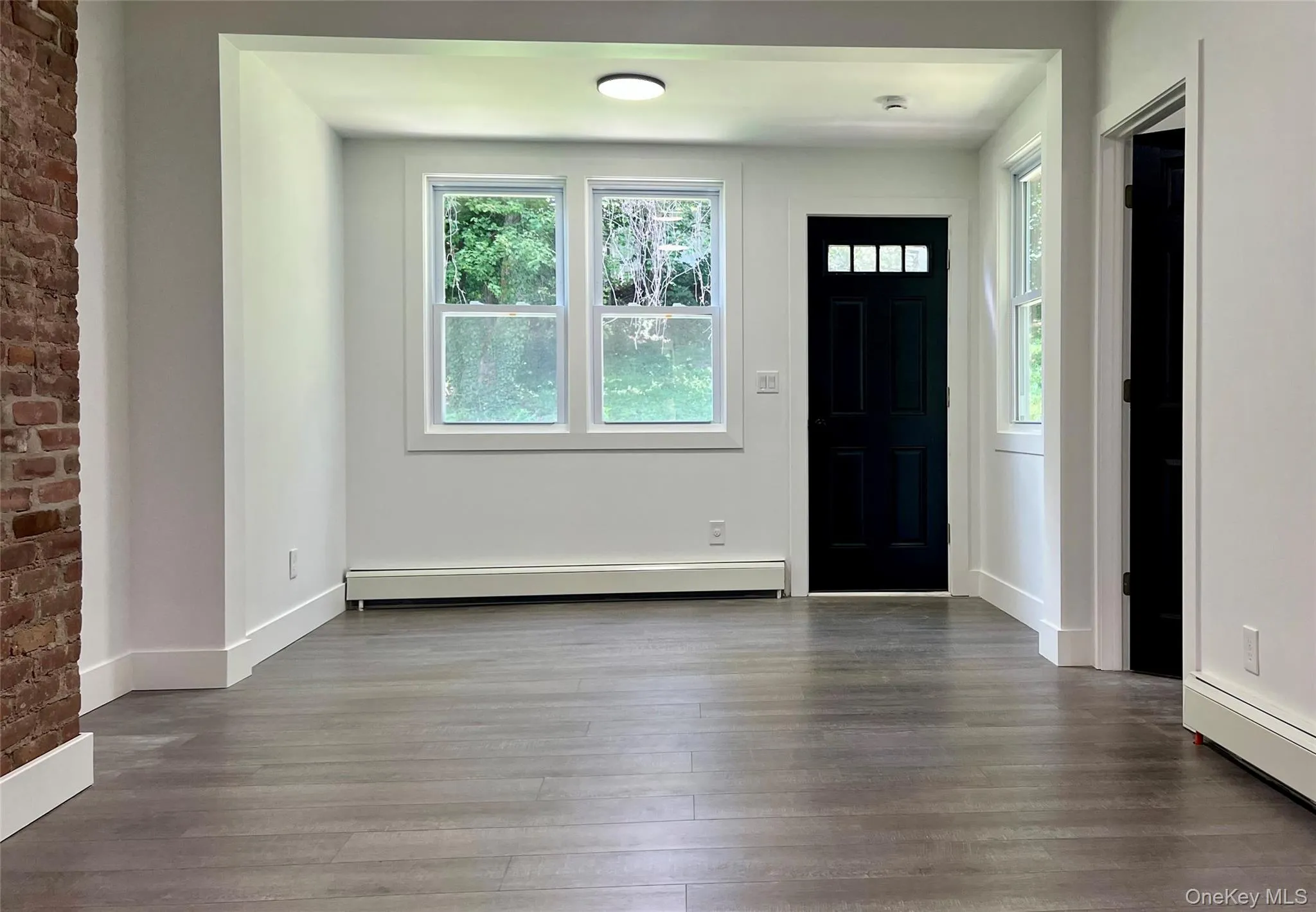 Foyer entrance with wood finished floors, a baseboard heating unit, and baseboard heating Foyer entrance with wood finished floors, a baseboard heating unit, and baseboard heating