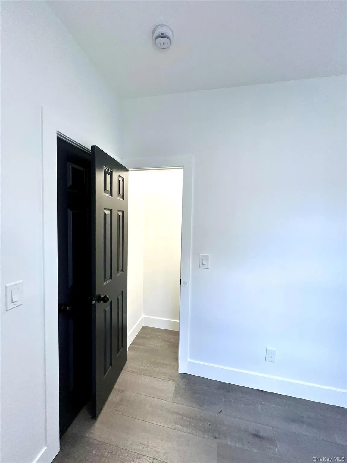 Unfurnished room with baseboards and wood finished floors Unfurnished room with baseboards and wood finished floors