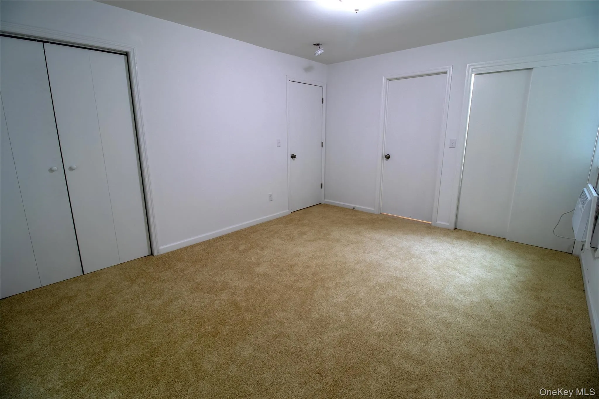 Unfurnished bedroom featuring two closets and light carpet Unfurnished bedroom featuring two closets and light carpet