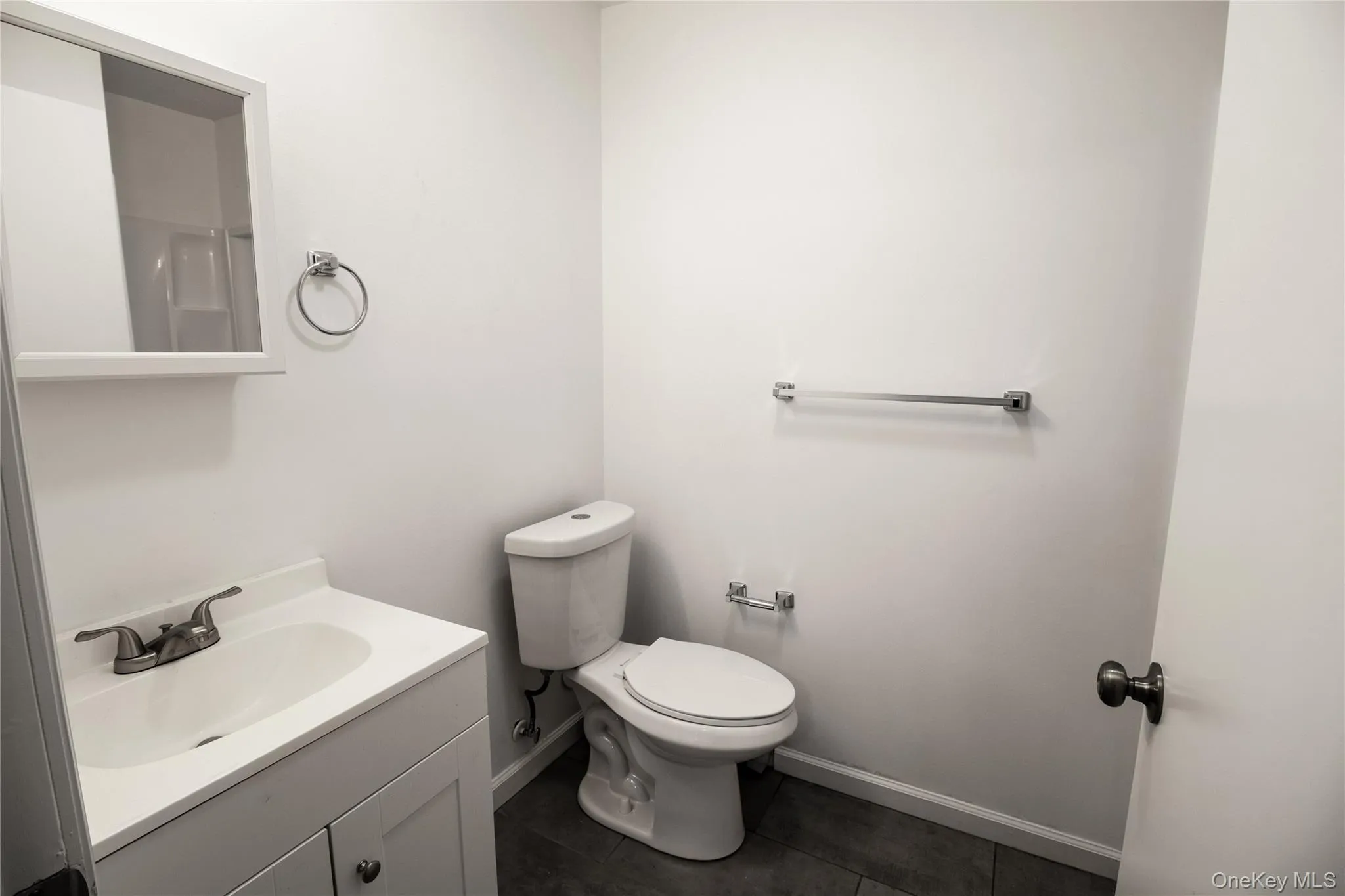 Bathroom featuring vanity and dark tile patterned floors Bathroom featuring vanity and dark tile patterned floors