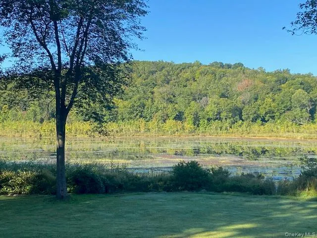 View of yard featuring a water view and a wooded view View of yard featuring a water view and a wooded view