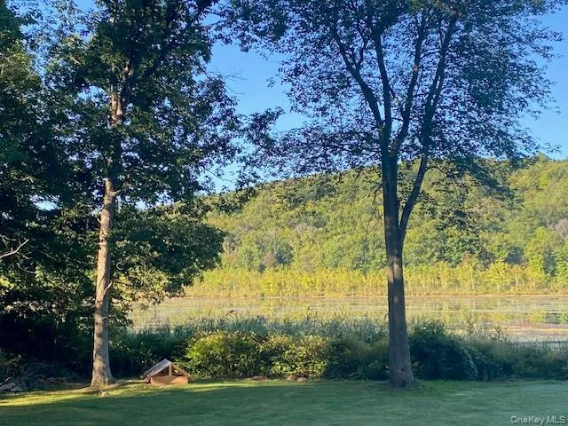 View of green lawn with a water view and a wooded view View of green lawn with a water view and a wooded view