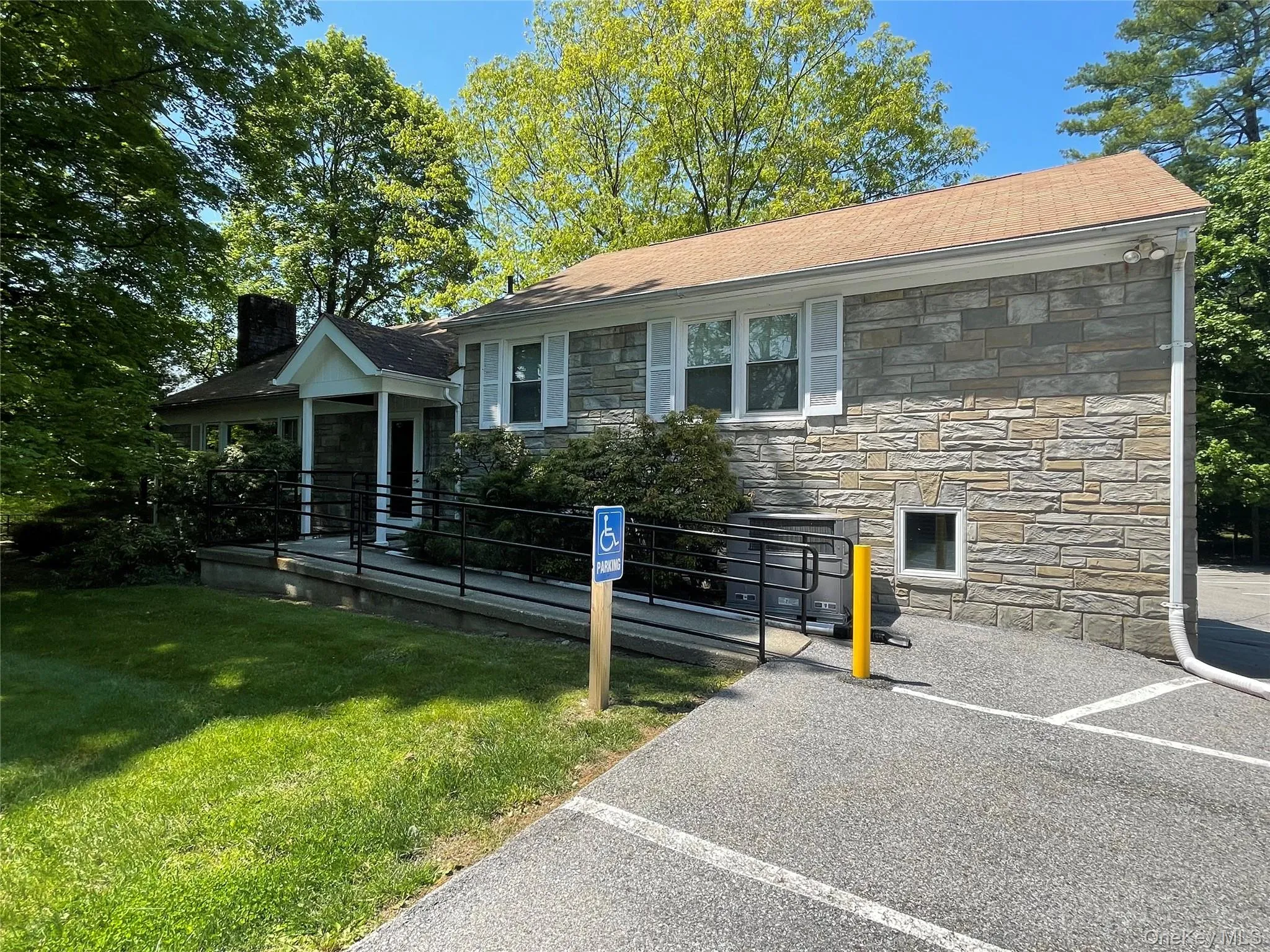 View of front of house with stone siding, a front lawn, and a chimney View of front of house with stone siding, a front lawn, and a chimney