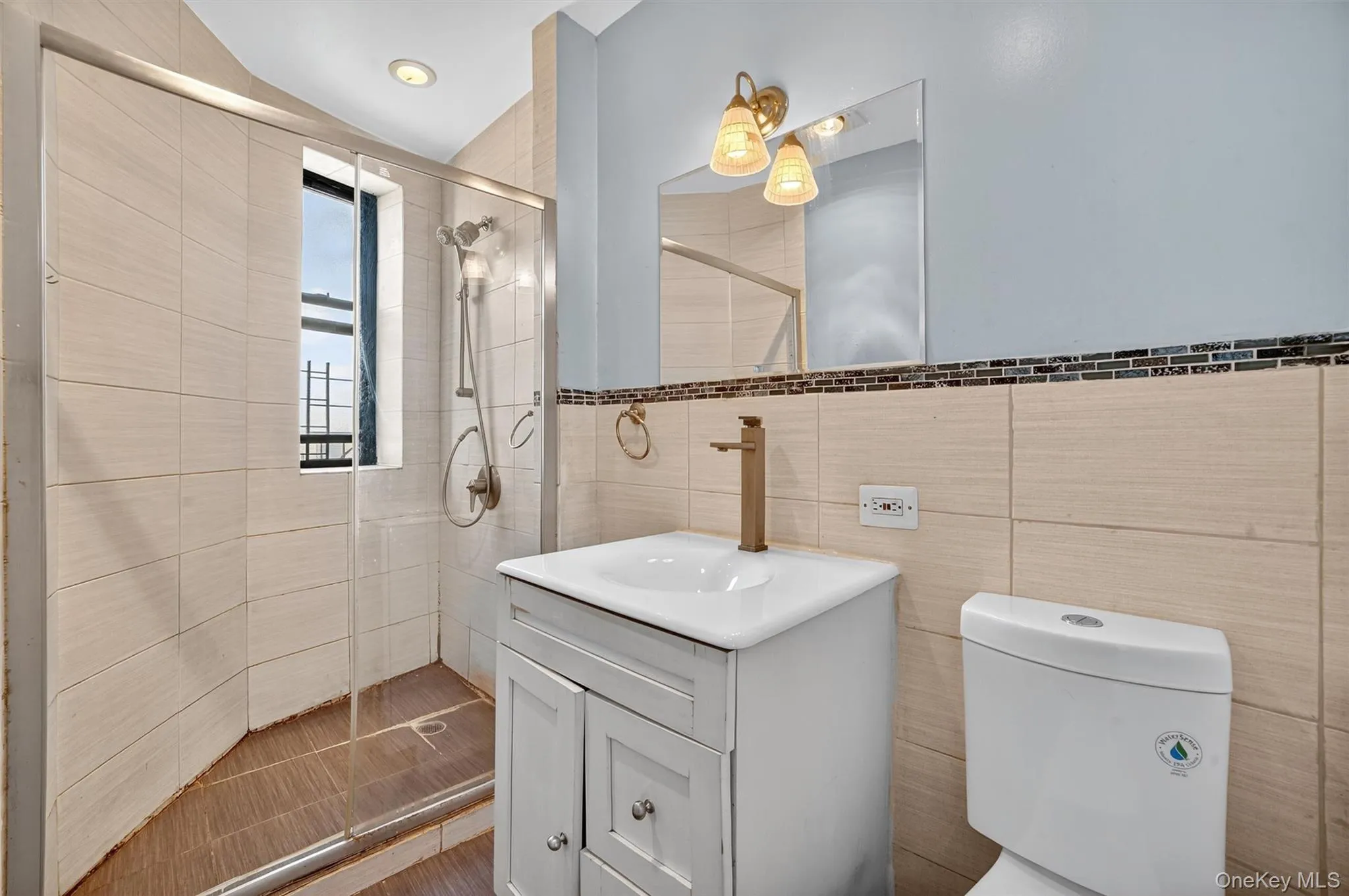 Bathroom with vanity, tile walls, and a stall shower Bathroom with vanity, tile walls, and a stall shower