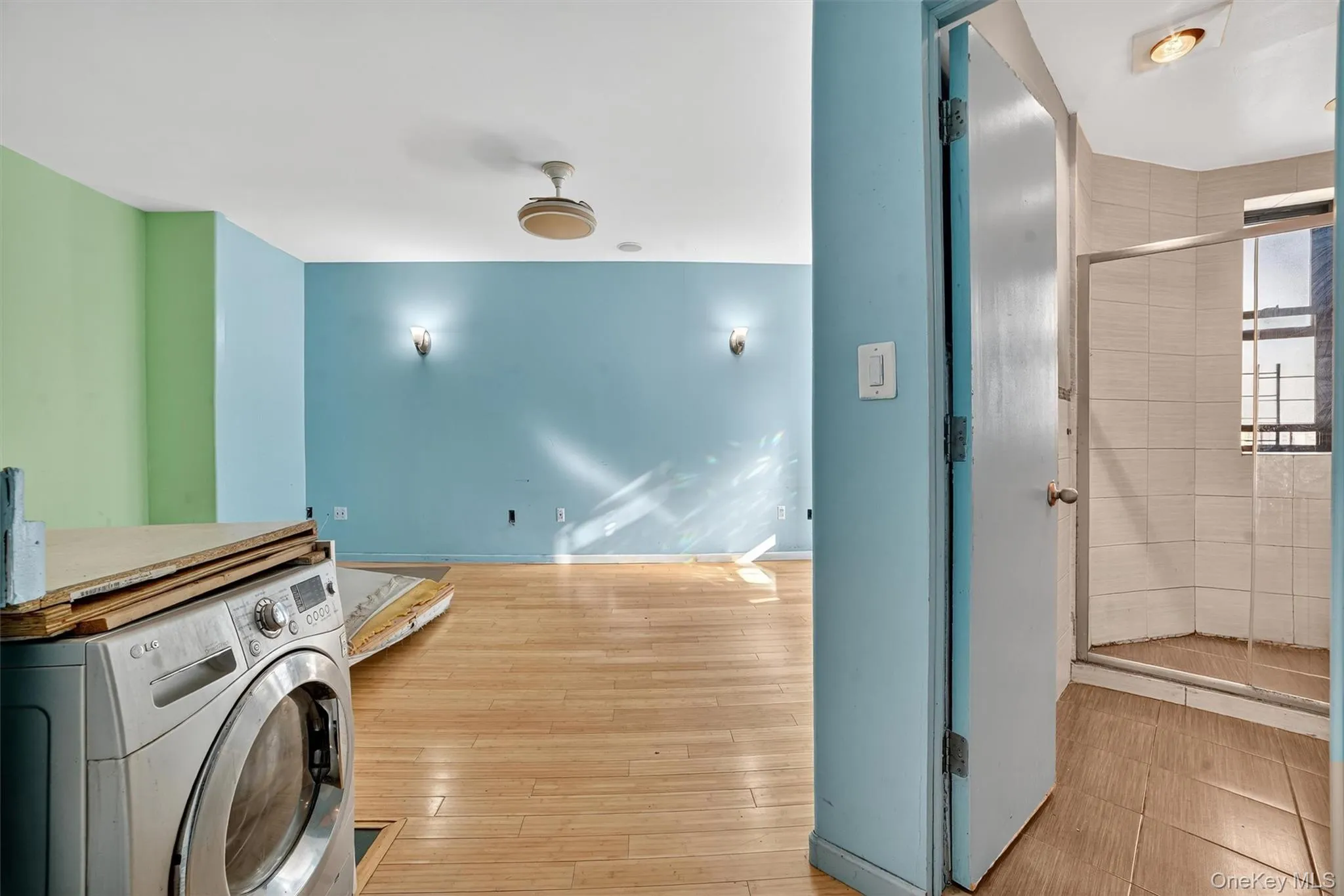 Laundry room featuring washer / dryer and wood-type flooring Laundry room featuring washer / dryer and wood-type flooring