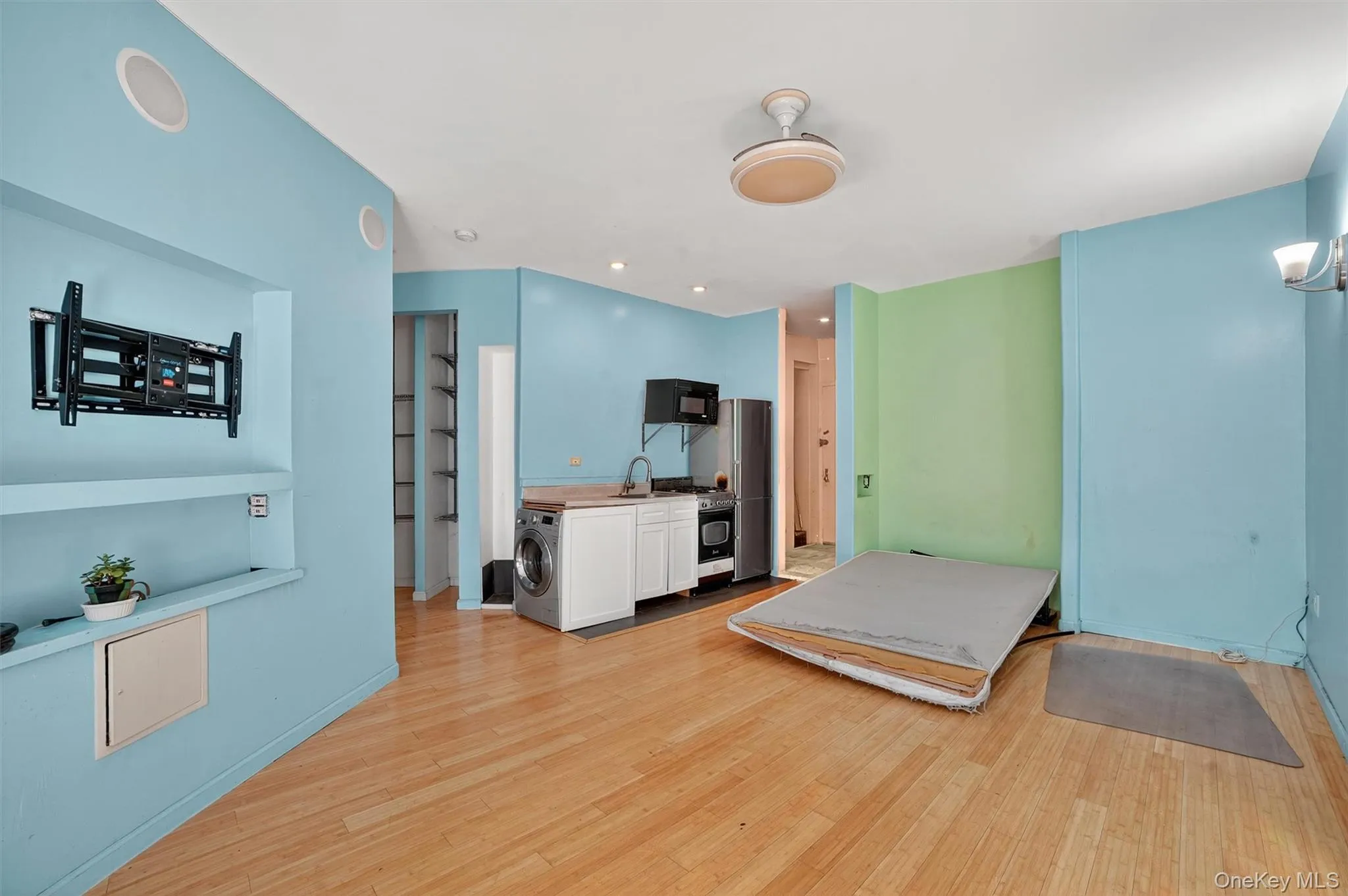 Bedroom featuring washer / clothes dryer, light wood-style floors, a chandelier, freestanding refrigerator, and recessed lighting Bedroom featuring washer / clothes dryer, light wood-style floors, a chandelier, freestanding refrigerator, and recessed lighting