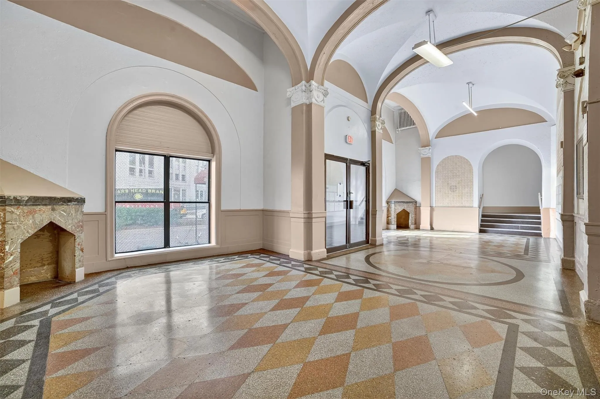 Common area with a wainscoted wall, a towering ceiling, and a decorative wall Common area with a wainscoted wall, a towering ceiling, and a decorative wall