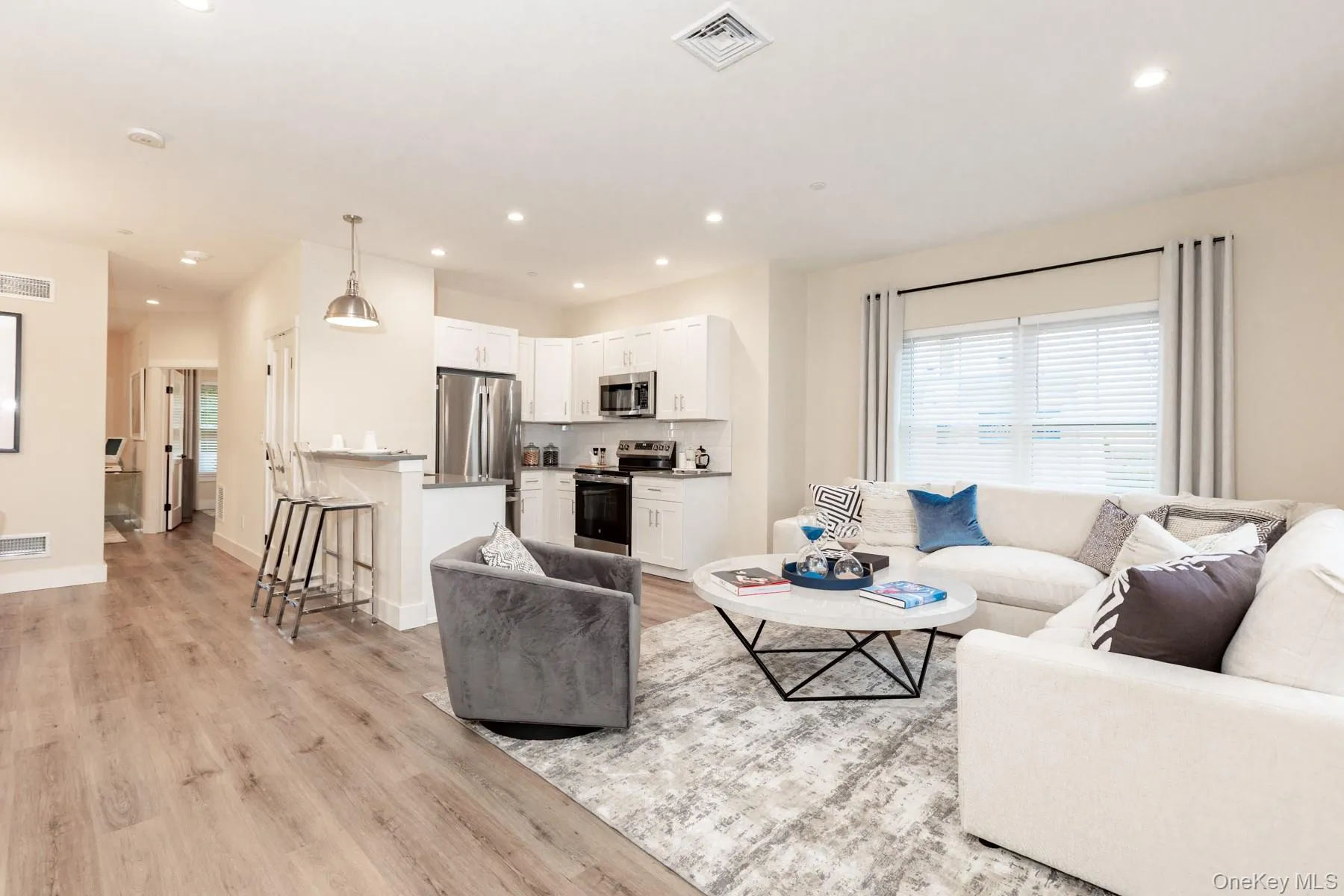 Living area featuring plenty of natural light, recessed lighting, and light wood-type flooring Living area featuring plenty of natural light, recessed lighting, and light wood-type flooring