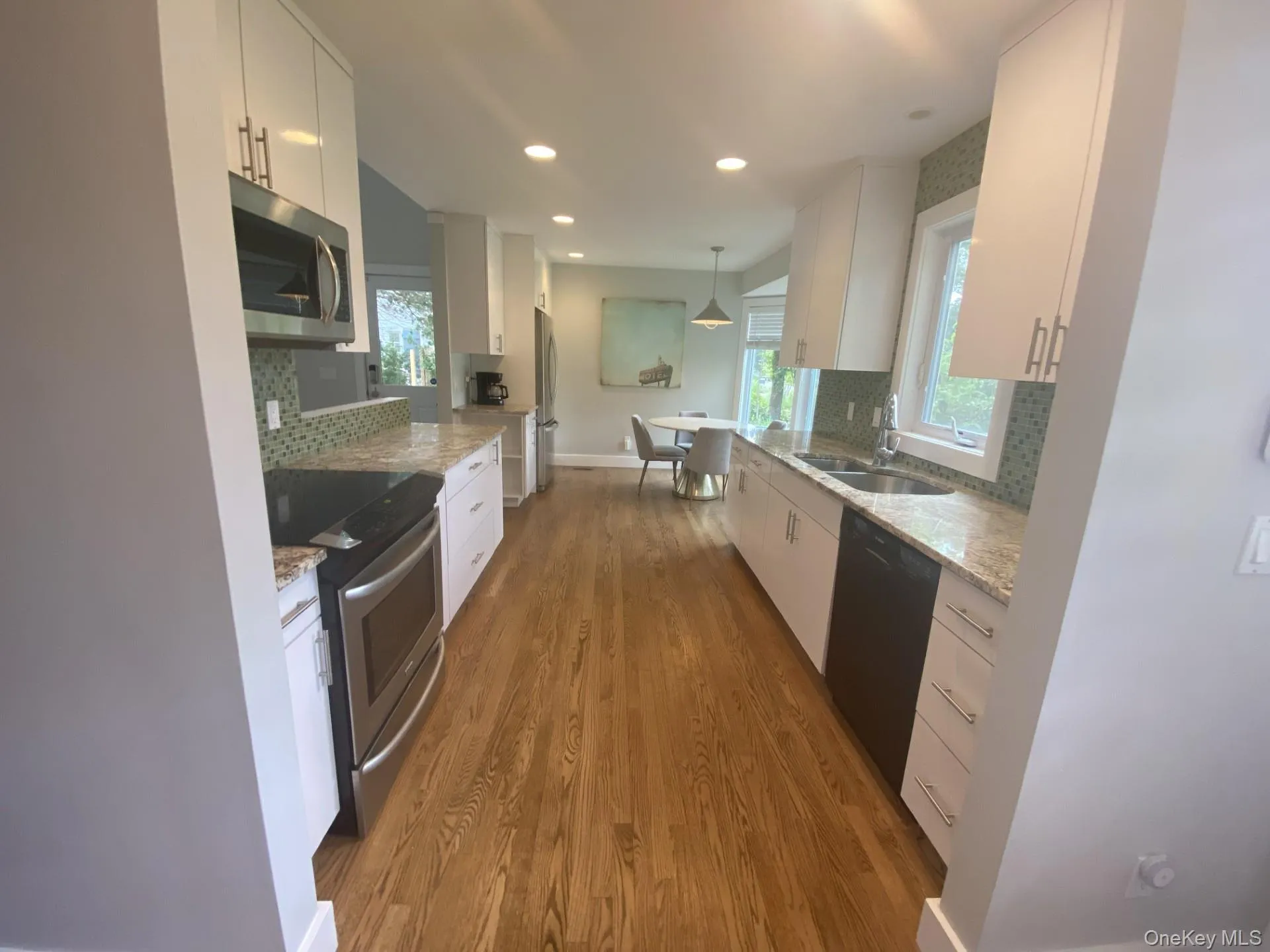 Kitchen featuring stainless steel appliances, light stone countertops, tasteful backsplash, white cabinetry, and recessed lighting Kitchen featuring stainless steel appliances, light stone countertops, tasteful backsplash, white cabinetry, and recessed lighting