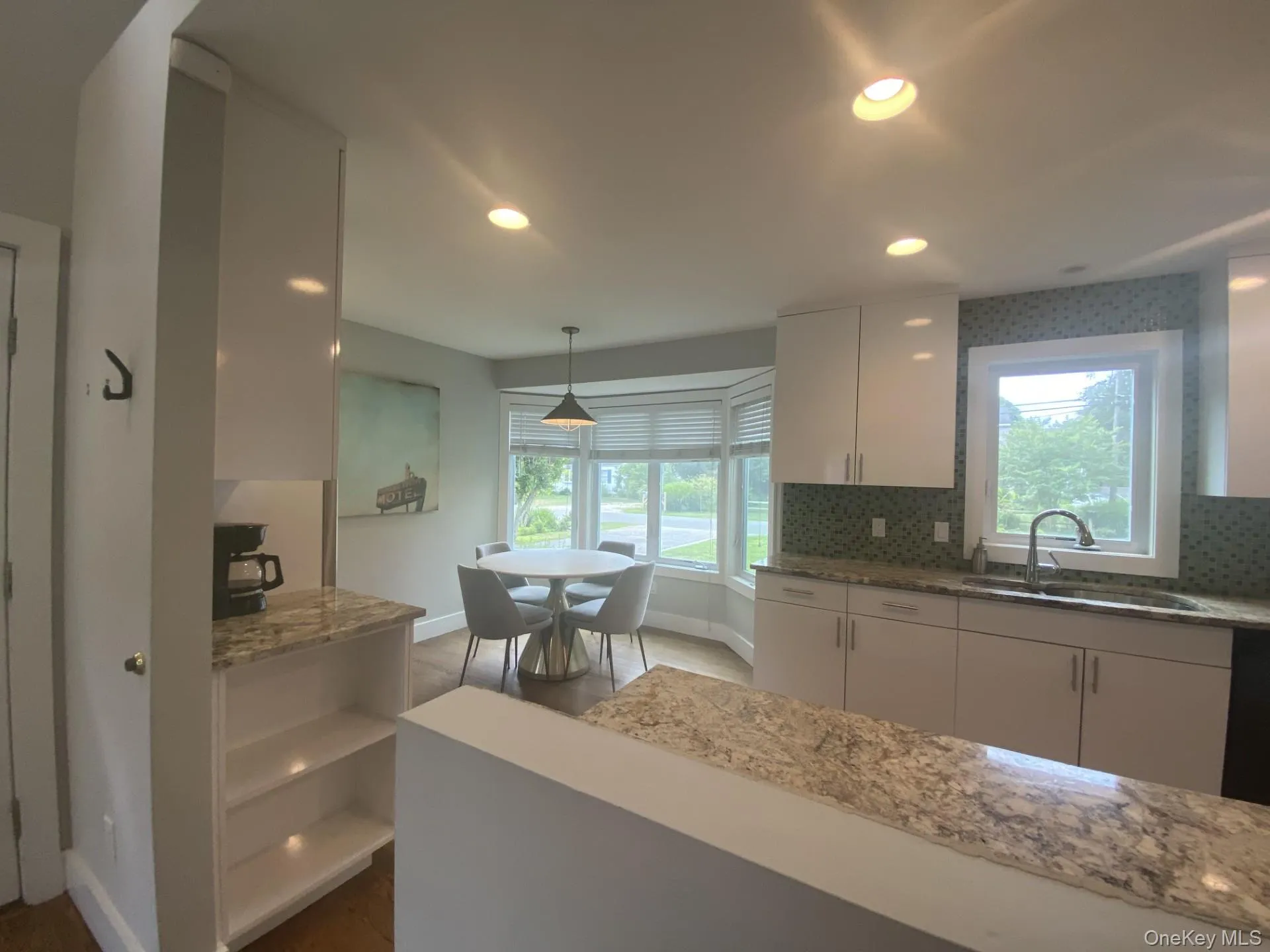 Kitchen with white cabinets, light stone counters, decorative light fixtures, recessed lighting, and tasteful backsplash Kitchen with white cabinets, light stone counters, decorative light fixtures, recessed lighting, and tasteful backsplash