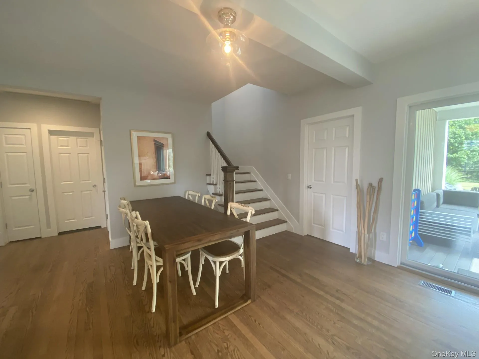 Dining space with stairway and dark wood-style floors Dining space with stairway and dark wood-style floors