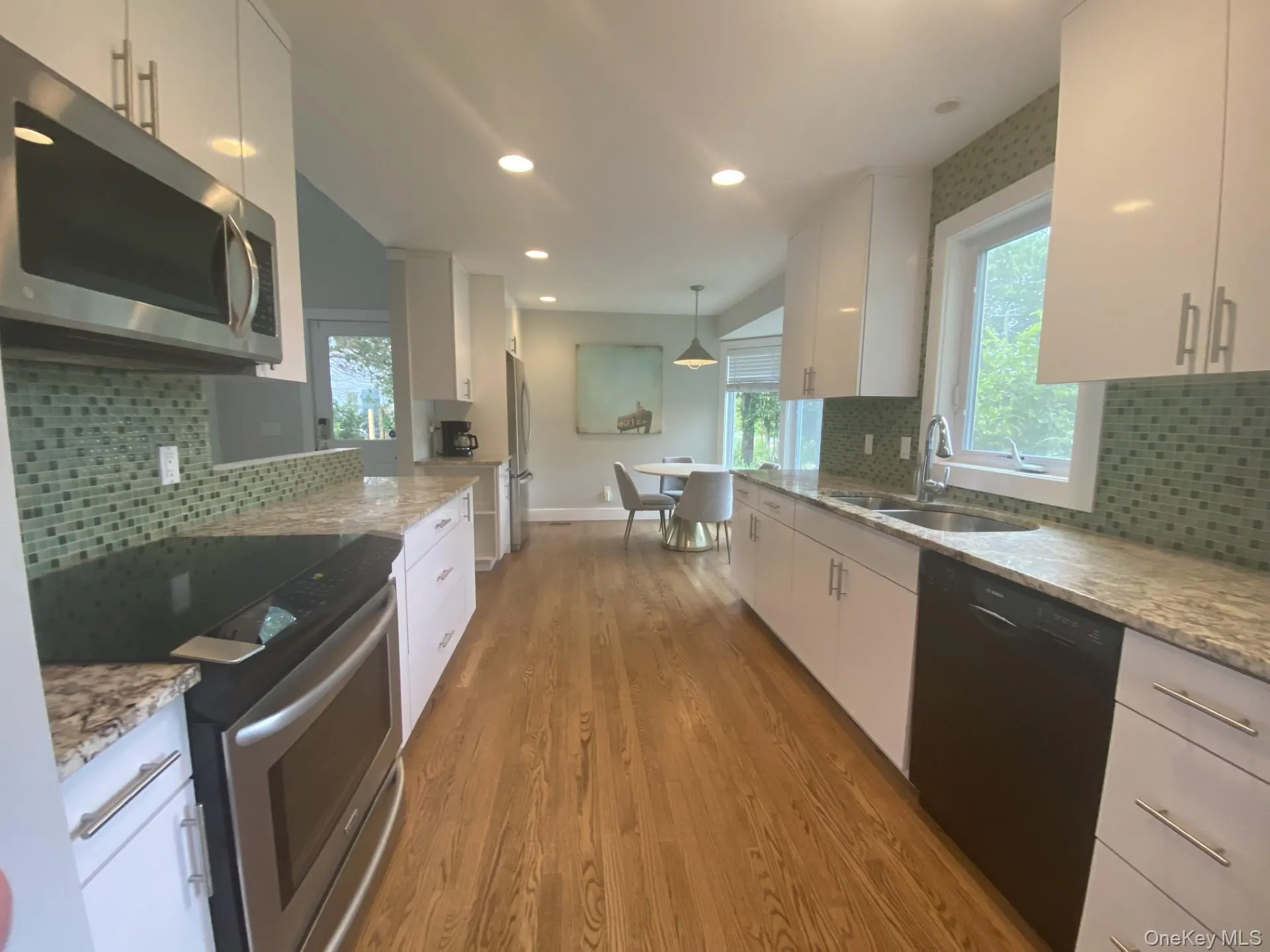 Kitchen featuring tasteful backsplash, appliances with stainless steel finishes, light stone counters, white cabinets, and recessed lighting Kitchen featuring tasteful backsplash, appliances with stainless steel finishes, light stone counters, white cabinets, and recessed lighting