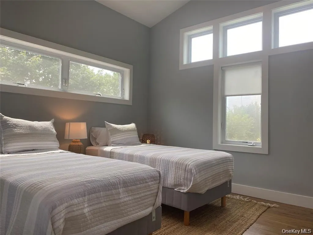 Bedroom with wood finished floors and vaulted ceiling Bedroom with wood finished floors and vaulted ceiling