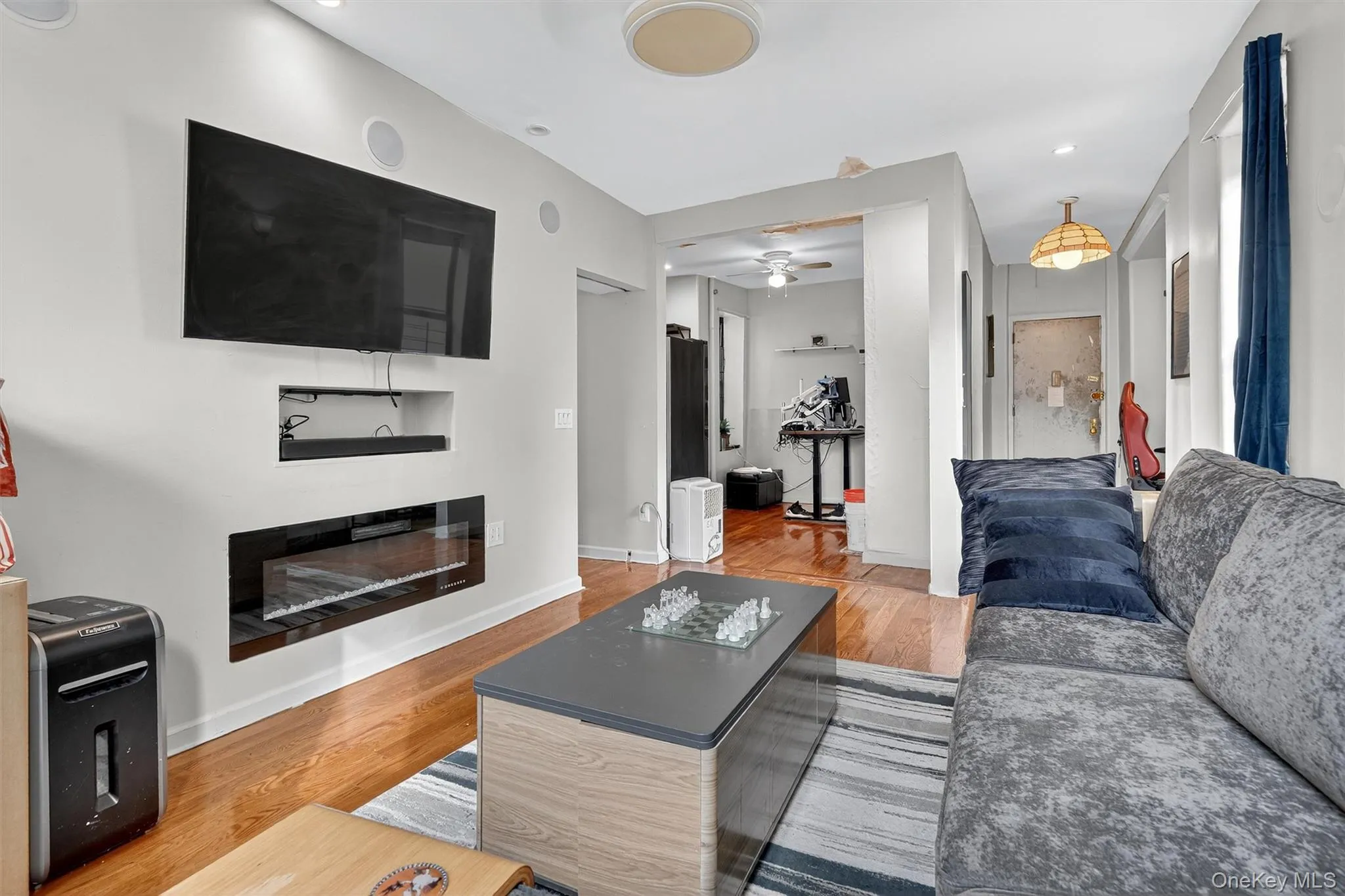 Living room featuring light wood finished floors, ceiling fan, and recessed lighting Living room featuring light wood finished floors, ceiling fan, and recessed lighting