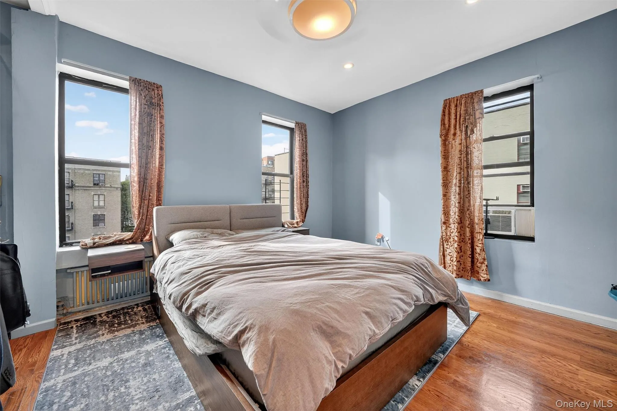 Bedroom featuring wood finished floors, multiple windows, and recessed lighting Bedroom featuring wood finished floors, multiple windows, and recessed lighting