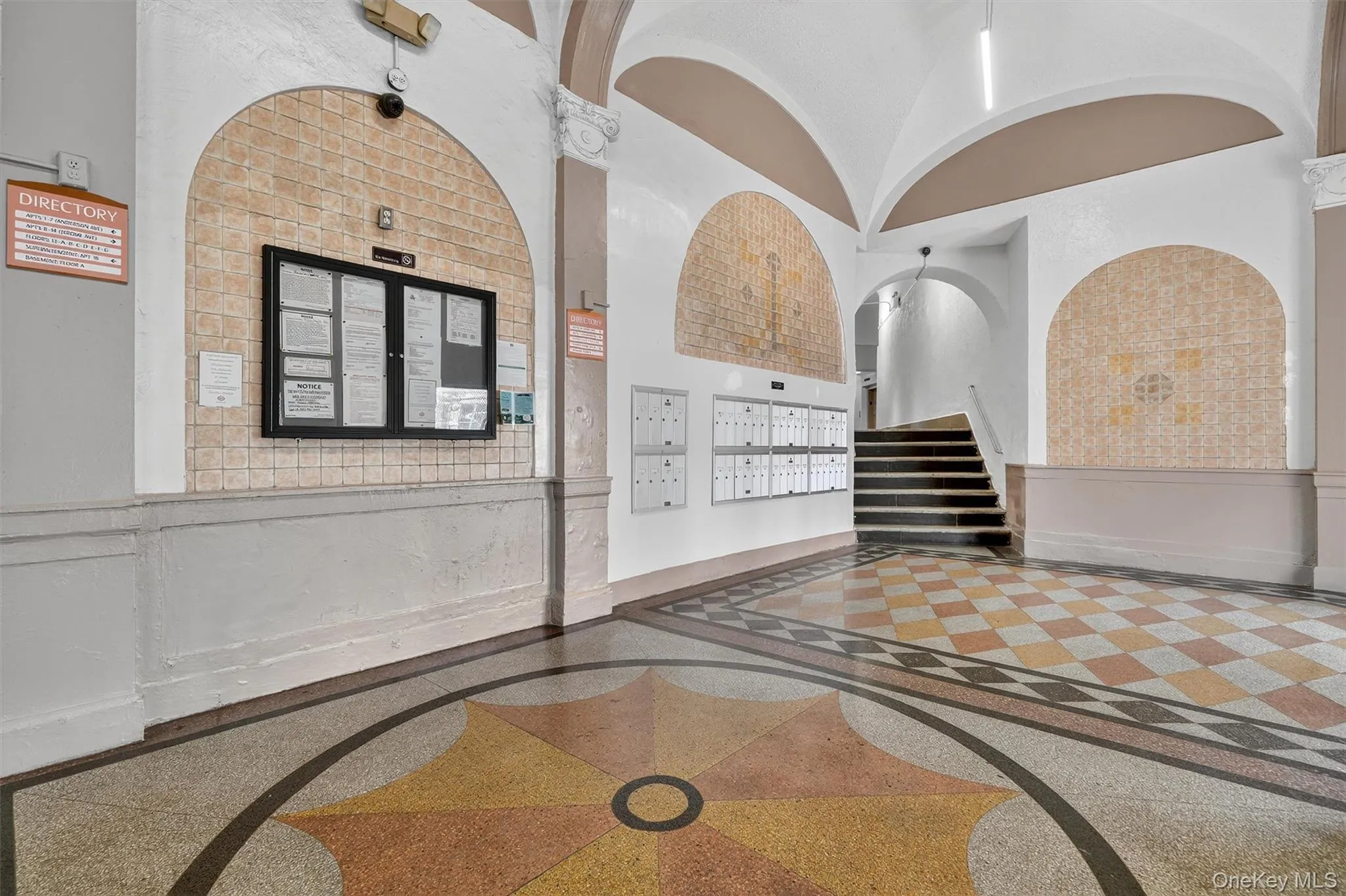 Community lobby featuring wainscoting, a towering ceiling, and a decorative wall Community lobby featuring wainscoting, a towering ceiling, and a decorative wall