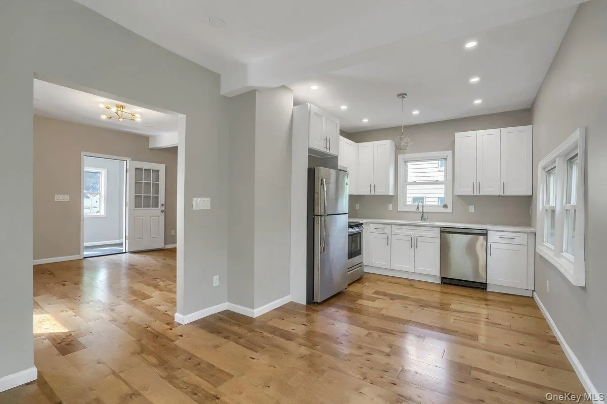 Kitchen with stainless steel appliances, white cabinetry, light wood-style floors, pendant lighting, and recessed lighting Kitchen with stainless steel appliances, white cabinetry, light wood-style floors, pendant lighting, and recessed lighting