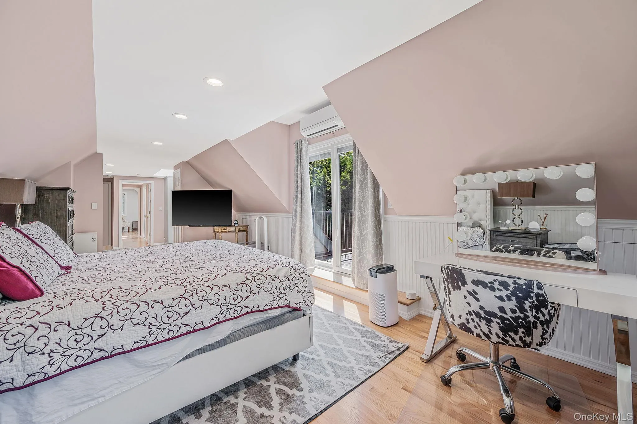 Bedroom featuring light wood-style floors, recessed lighting, wainscoting, vaulted ceiling, and an office area Bedroom featuring light wood-style floors, recessed lighting, wainscoting, vaulted ceiling, and an office area