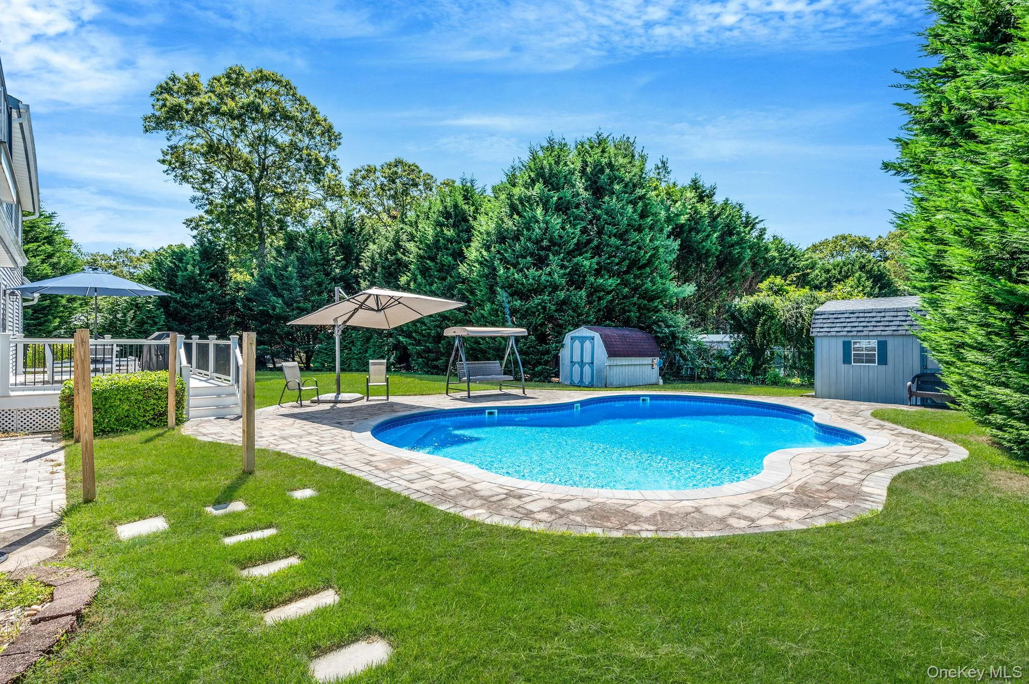 Swimming pool featuring a shed, a patio area, a yard, and a deck Swimming pool featuring a shed, a patio area, a yard, and a deck