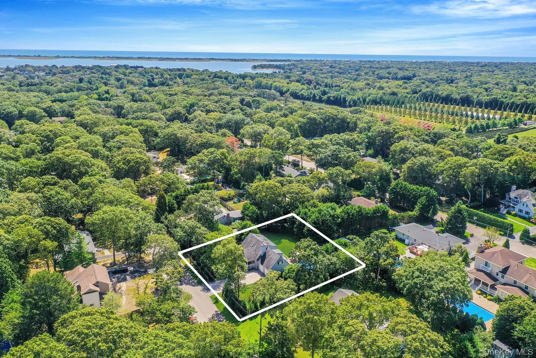 Aerial view of residential area with property parcel outlined and a nearby body of water Aerial view of residential area with property parcel outlined and a nearby body of water