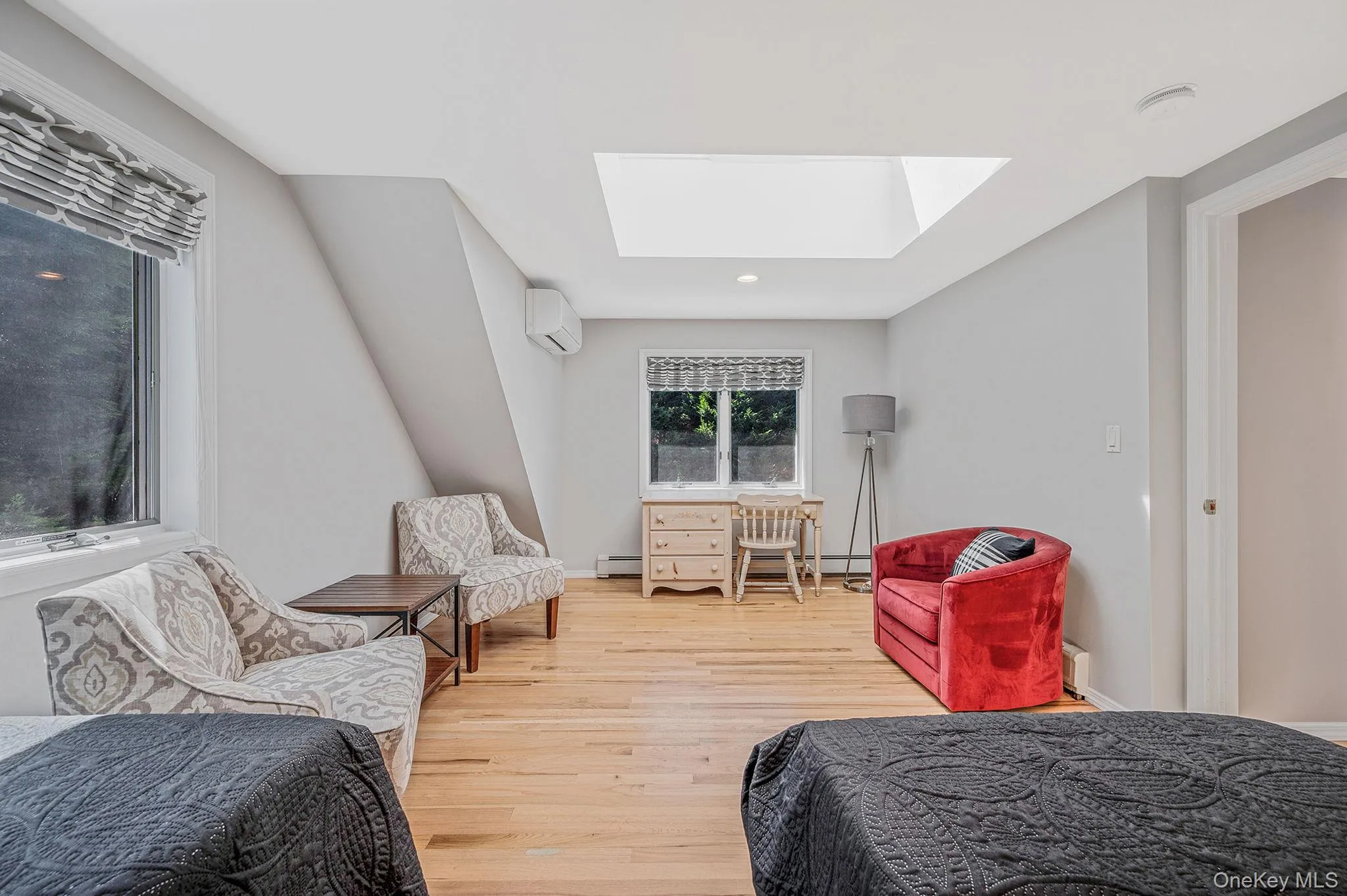 Bedroom with a skylight, light wood finished floors, and recessed lighting Bedroom with a skylight, light wood finished floors, and recessed lighting