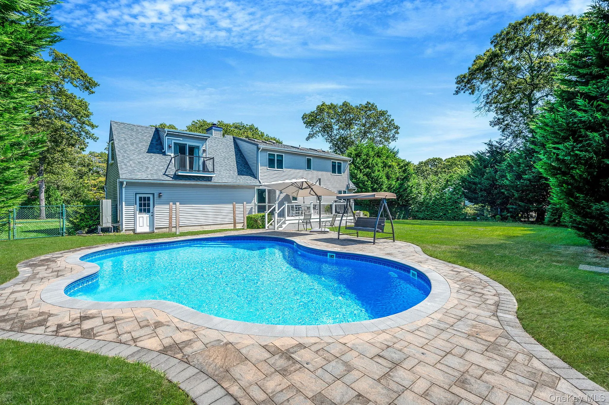 View of pool with a patio area and view of scattered trees View of pool with a patio area and view of scattered trees