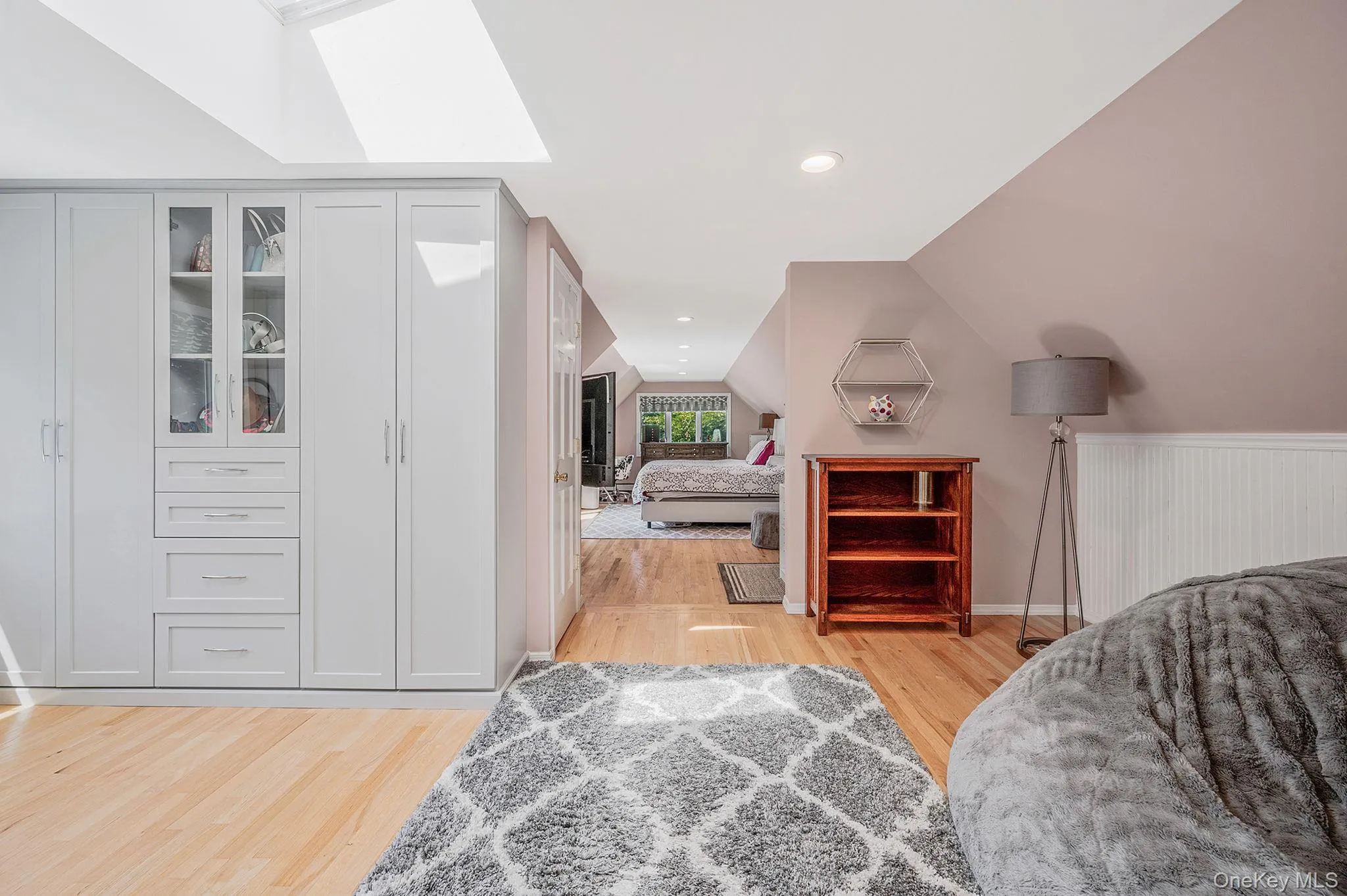Bedroom with lofted ceiling, a skylight, light wood-style flooring, and recessed lighting Bedroom with lofted ceiling, a skylight, light wood-style flooring, and recessed lighting