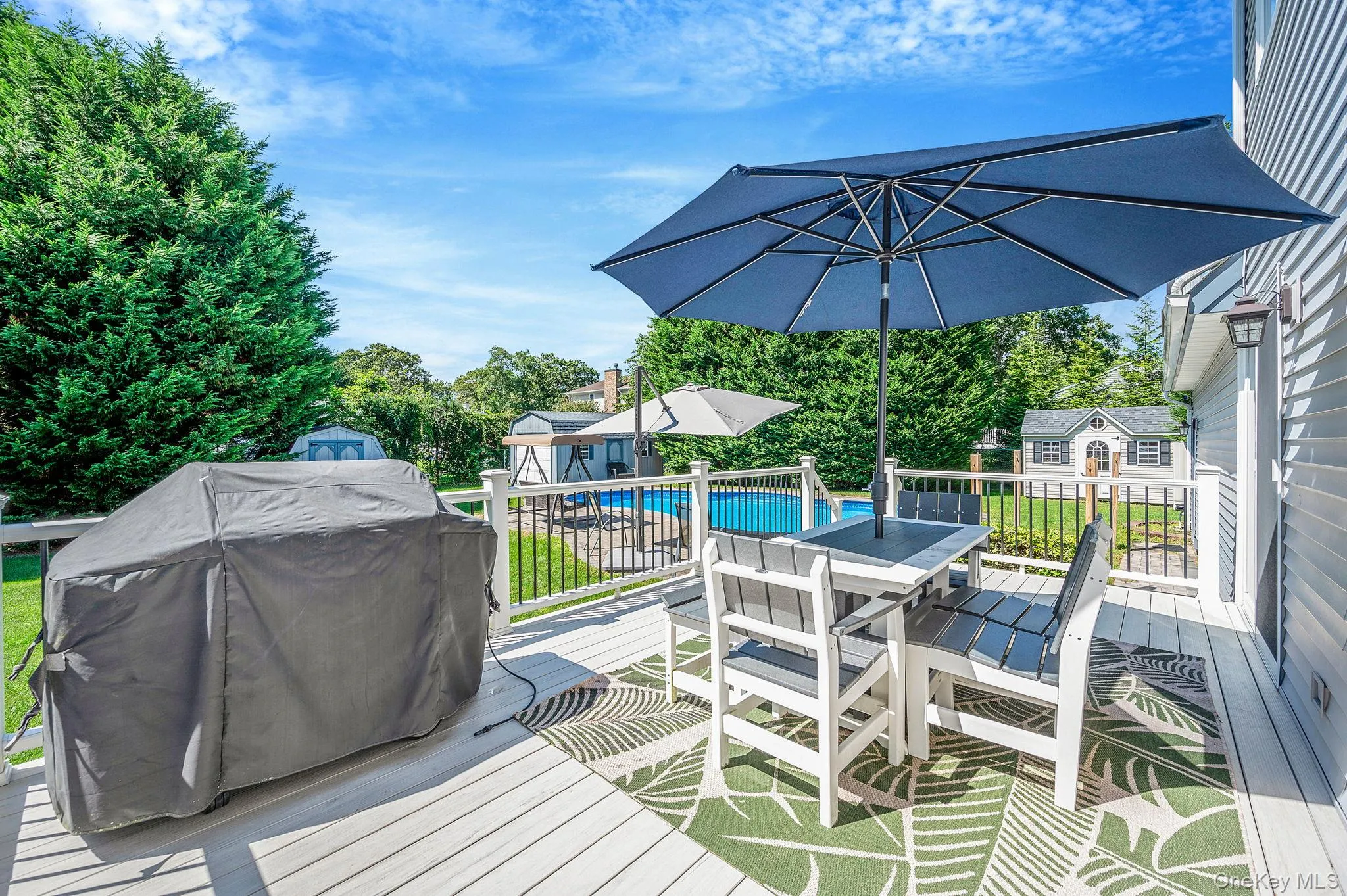 Wooden deck with a grill, outdoor dining area, and an outbuilding Wooden deck with a grill, outdoor dining area, and an outbuilding