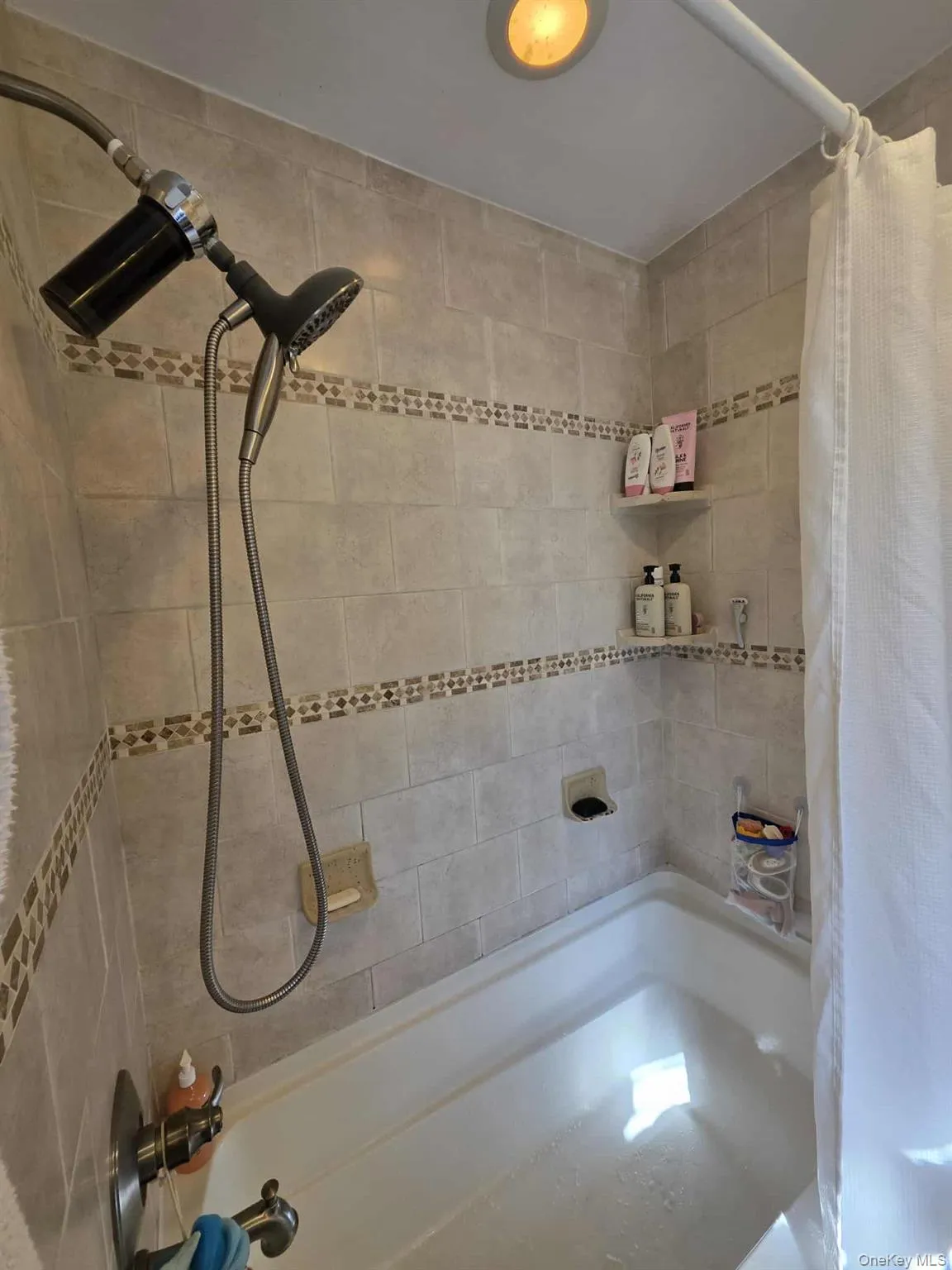 Bathroom with shower / bathtub combination with curtain Bathroom with shower / bathtub combination with curtain
