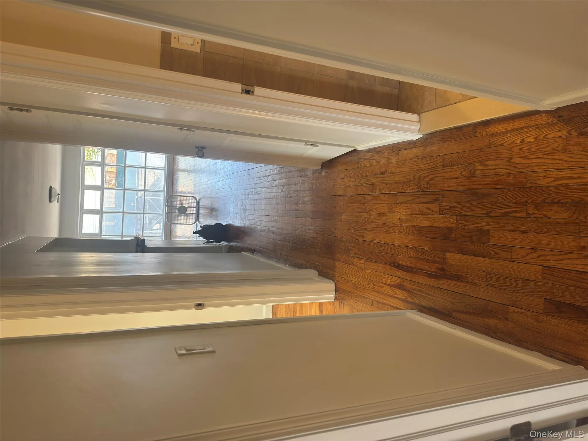 Hall with dark wood-type flooring and baseboards Hall with dark wood-type flooring and baseboards