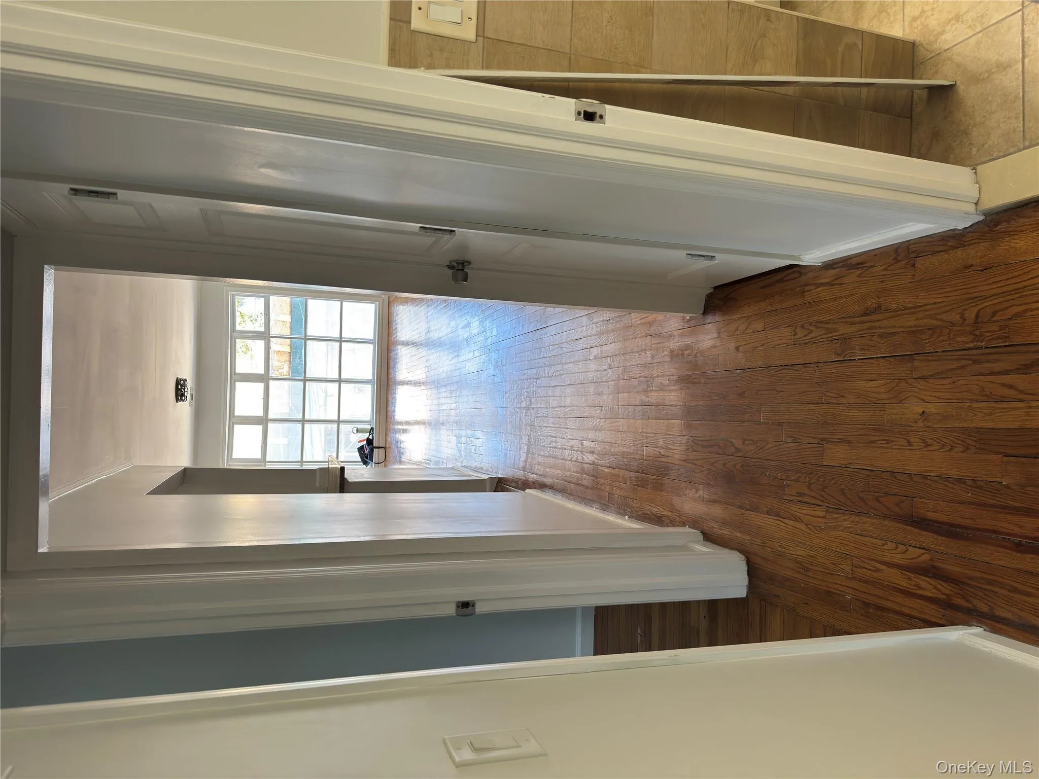Hallway featuring wood finished floors and ornamental molding Hallway featuring wood finished floors and ornamental molding