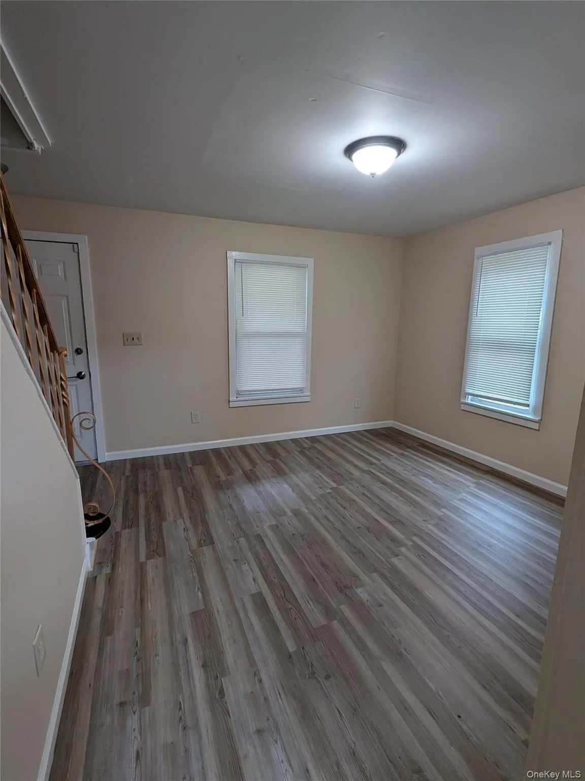 Empty room featuring light wood-style floors and stairway Empty room featuring light wood-style floors and stairway