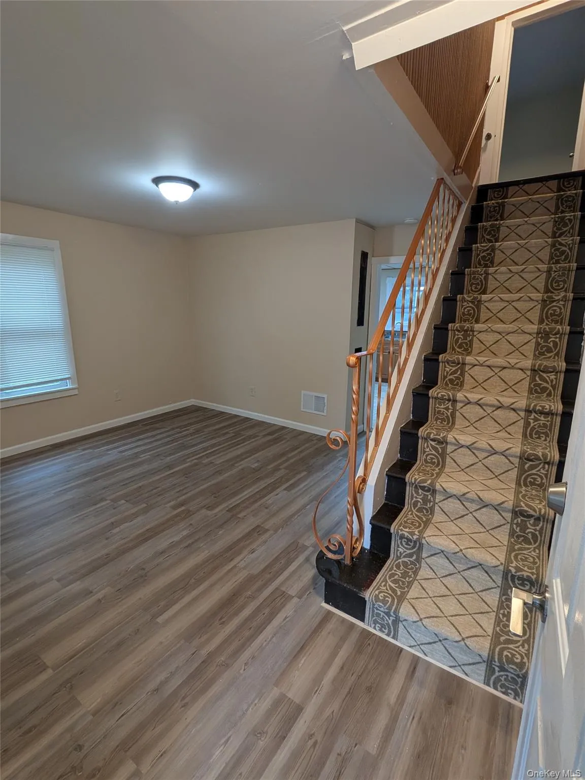 Below grade area featuring light wood-style flooring and stairs Below grade area featuring light wood-style flooring and stairs