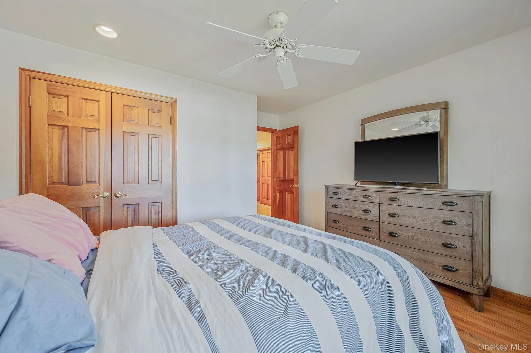 Bedroom with wood finished floors, a ceiling fan, a closet, and recessed lighting Bedroom with wood finished floors, a ceiling fan, a closet, and recessed lighting