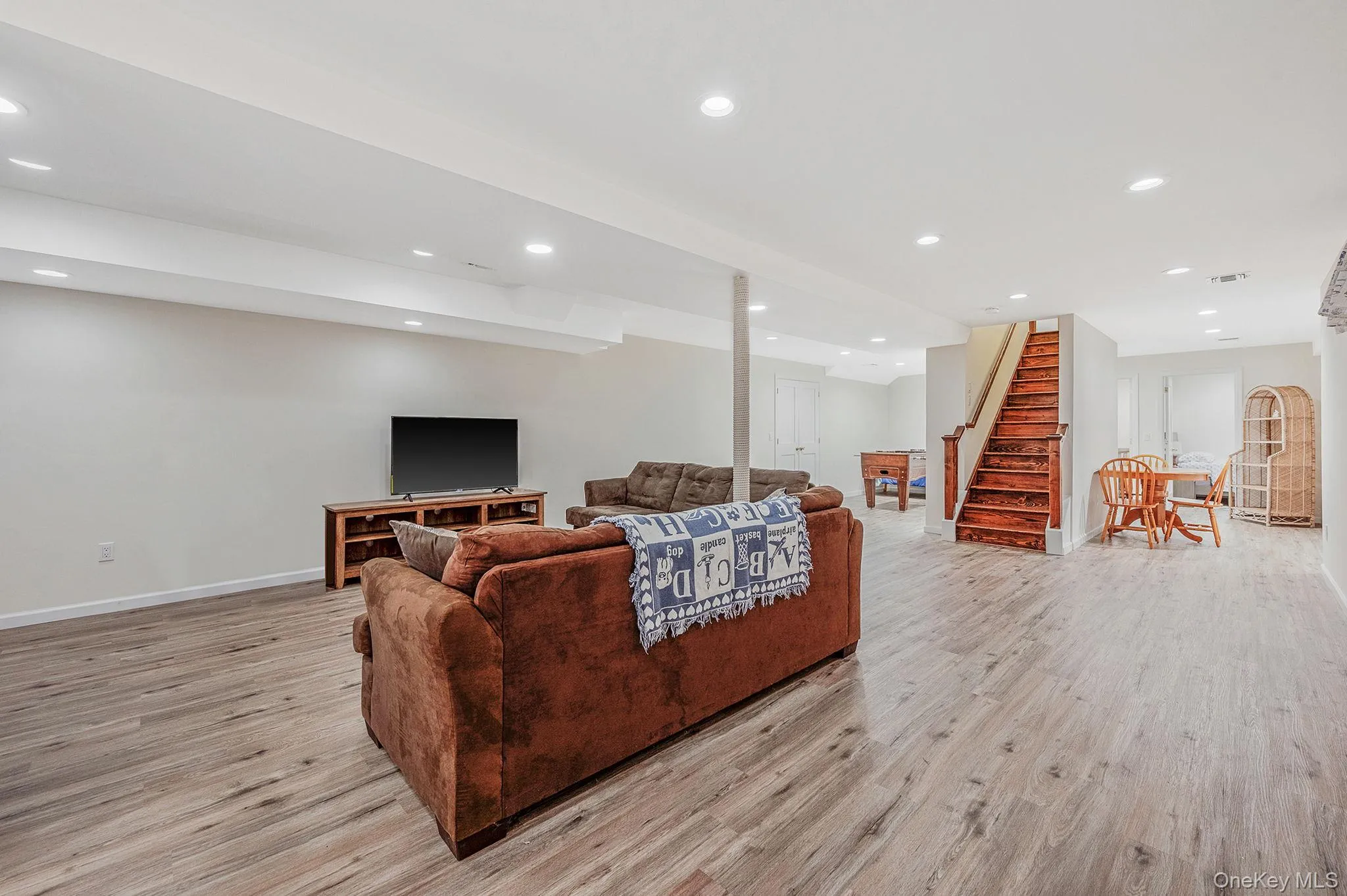 Living room featuring recessed lighting, stairway, and light wood-type flooring Living room featuring recessed lighting, stairway, and light wood-type flooring