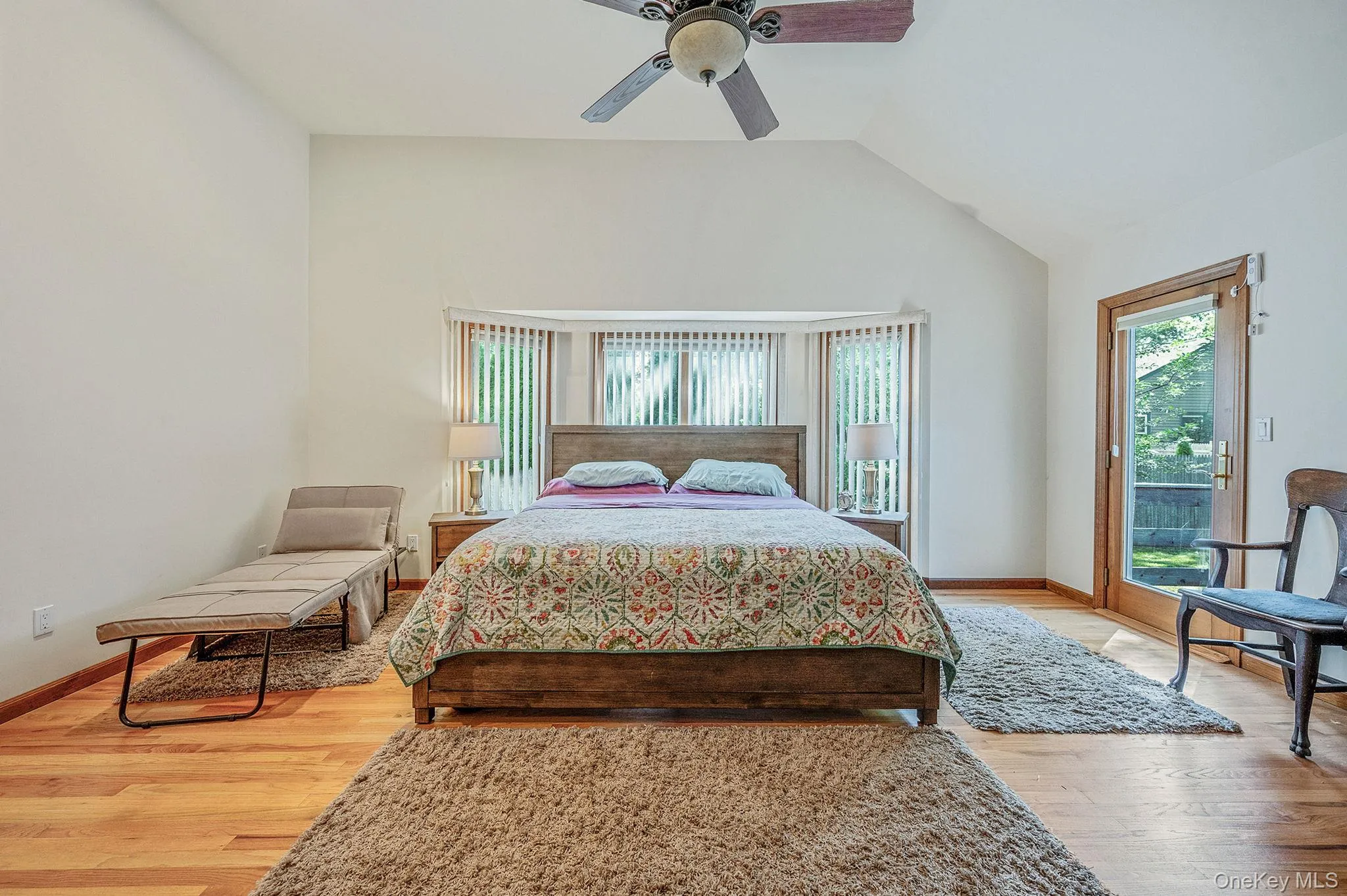 Bedroom with vaulted ceiling, access to outside, light wood finished floors, and ceiling fan Bedroom with vaulted ceiling, access to outside, light wood finished floors, and ceiling fan