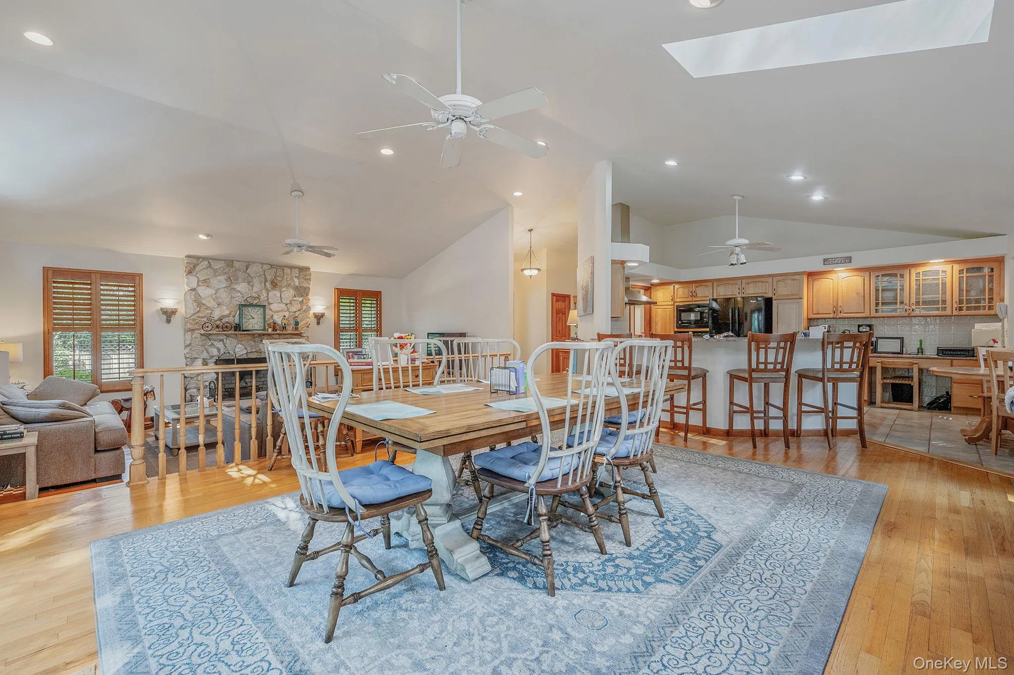 Dining area with light wood-style flooring, a skylight, recessed lighting, a ceiling fan, and high vaulted ceiling Dining area with light wood-style flooring, a skylight, recessed lighting, a ceiling fan, and high vaulted ceiling