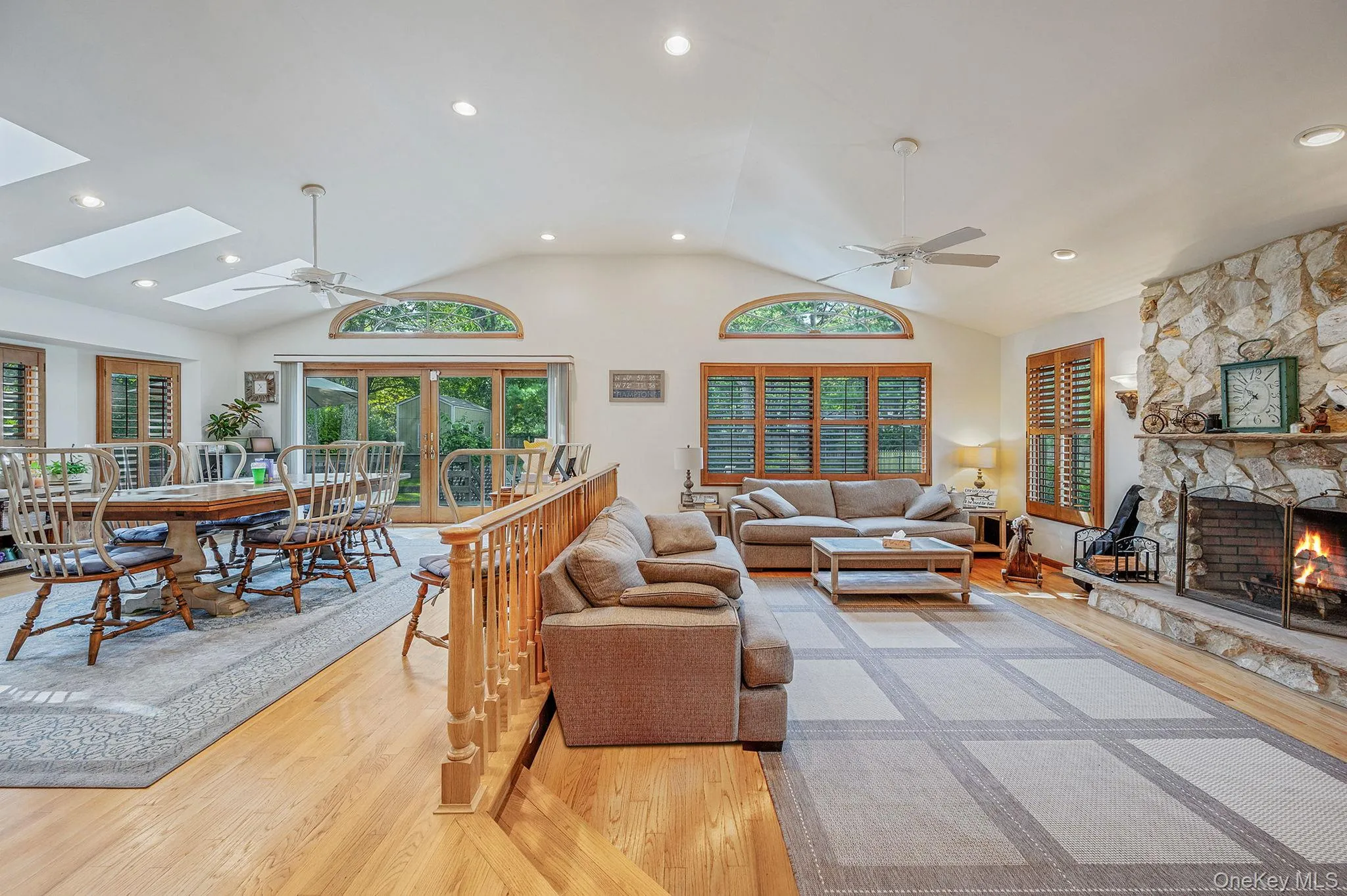 Living area with light wood finished floors, a ceiling fan, a fireplace, recessed lighting, and a skylight Living area with light wood finished floors, a ceiling fan, a fireplace, recessed lighting, and a skylight